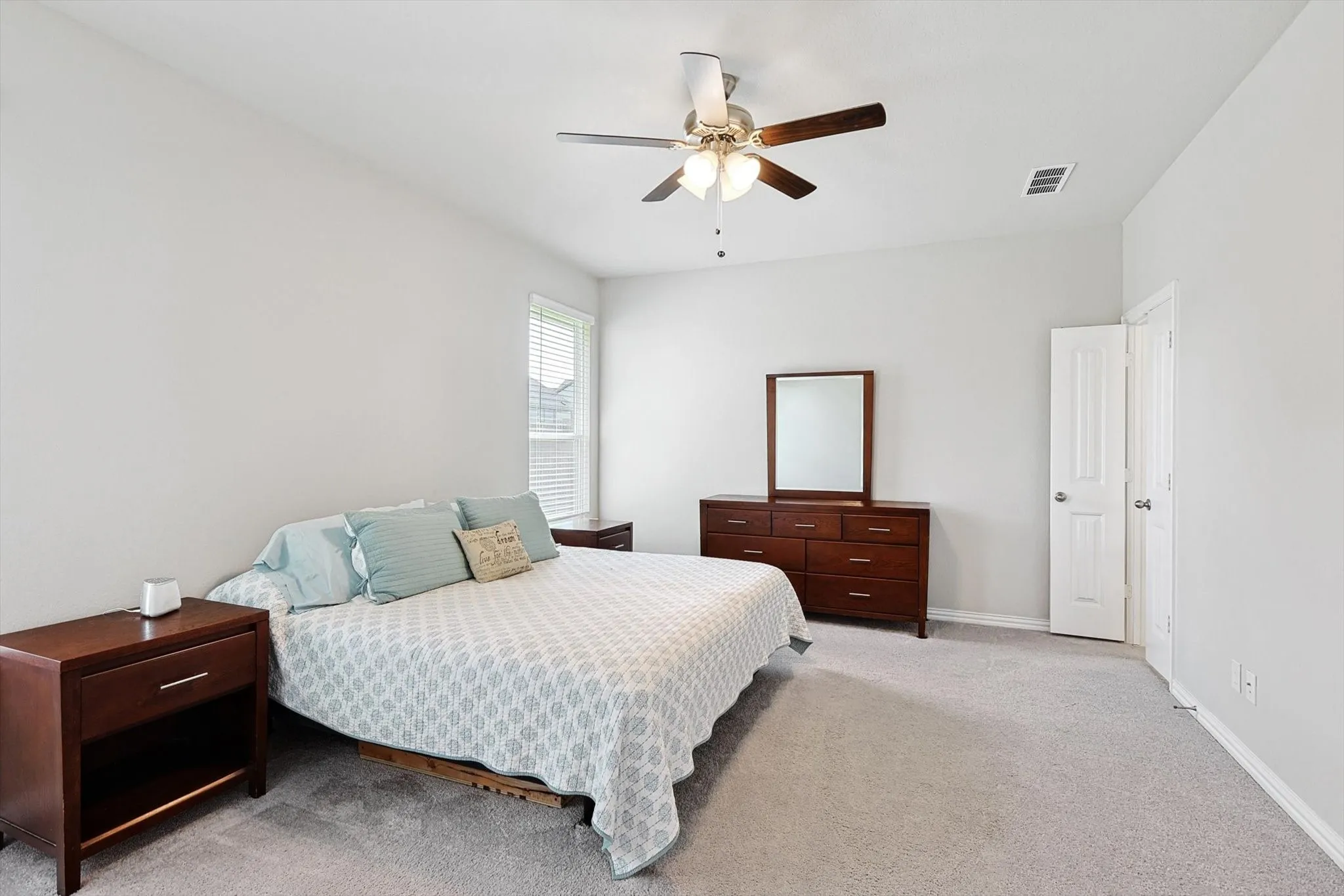Wall-to-wall carpeting, ceiling fan with integrated lighting, and window with blinds