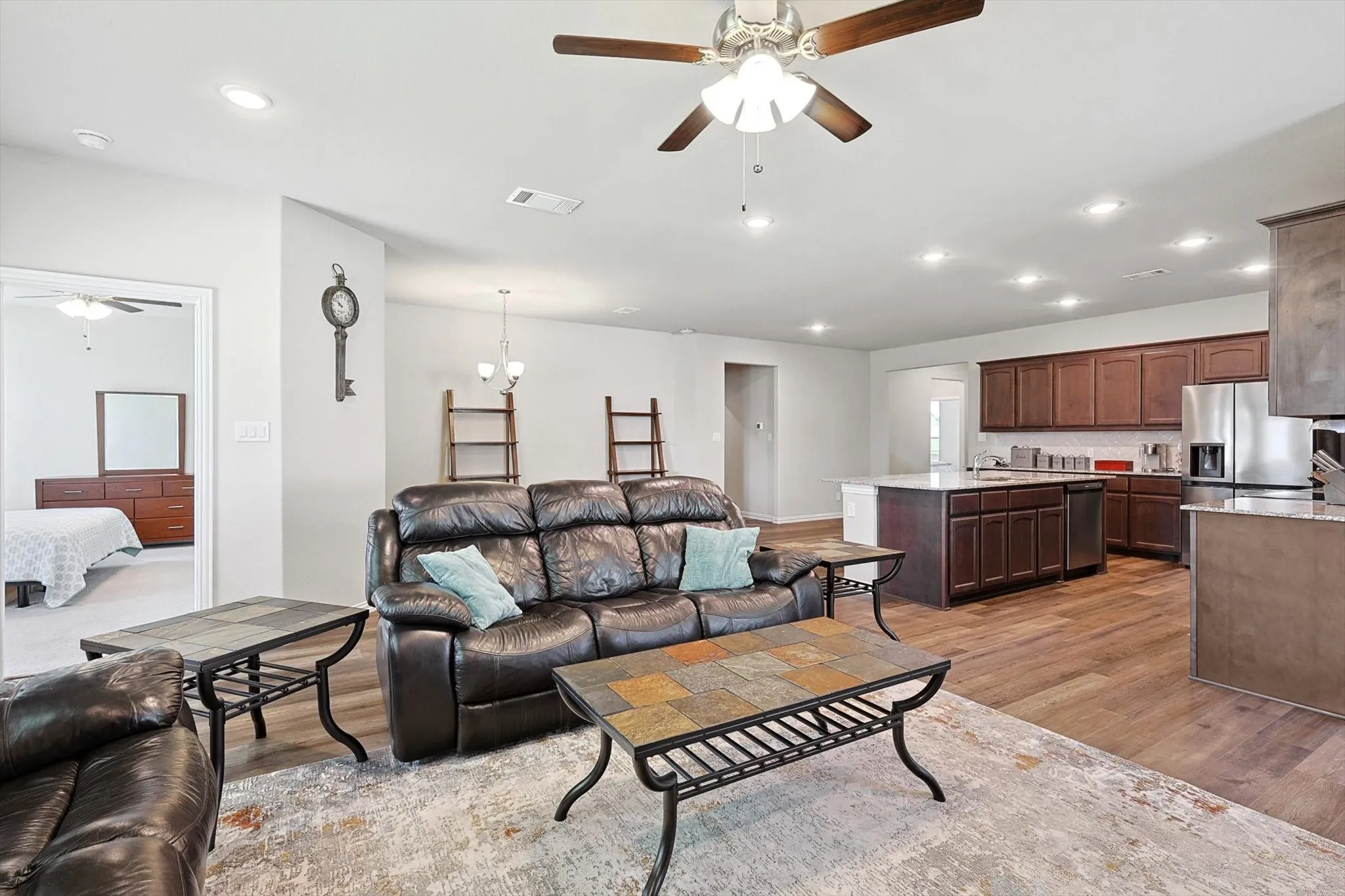 Open-concept living area with wood-finish flooring, recessed lighting, and a ceiling fan