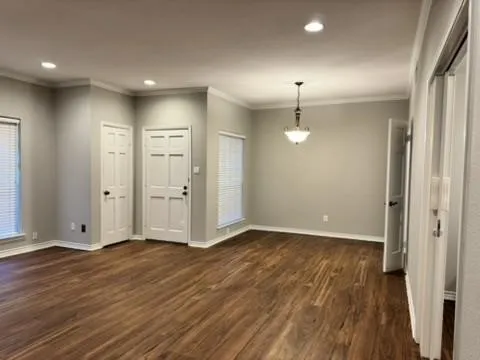 Wood-finish flooring throughout, recessed lighting, crown molding, and a chandelier light fixture