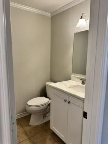 White vanity with double cabinet doors, a drop-in sink, and a light-colored countertop