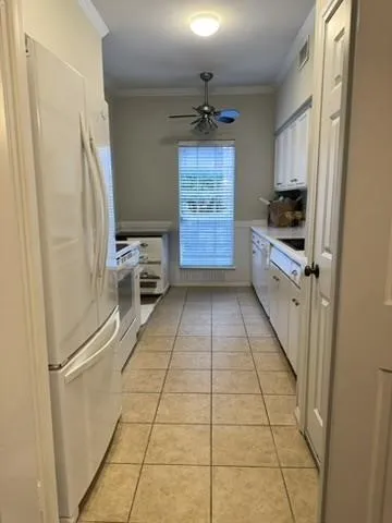 Kitchen featuring tile flooring, white cabinetry, a single window, white appliances, and a ceiling fan