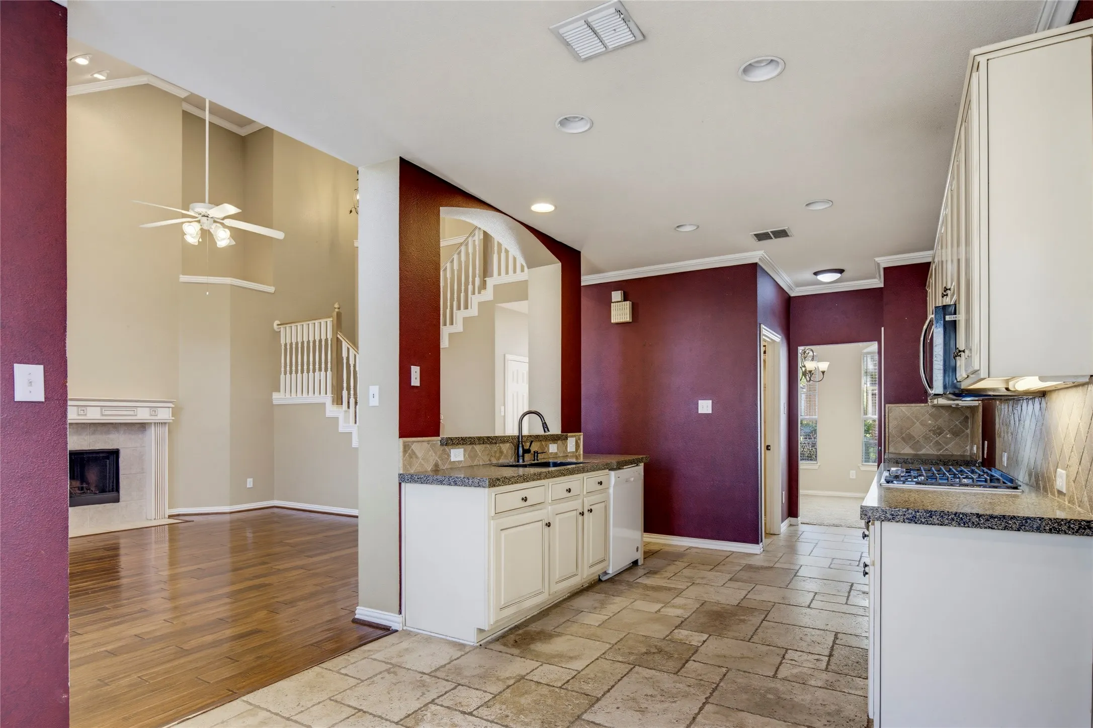 Kitchen featuring stone tile flooring, granite countertops, and white cabinetry