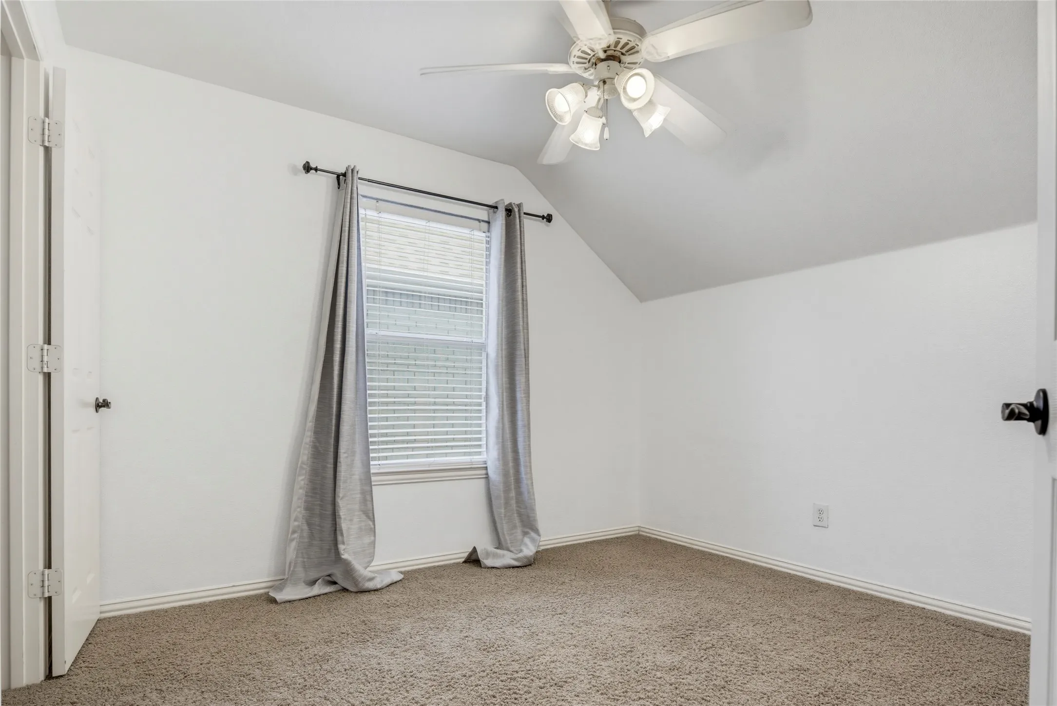 Carpeted room featuring a ceiling fan with integrated lighting, a window with blinds, and white walls