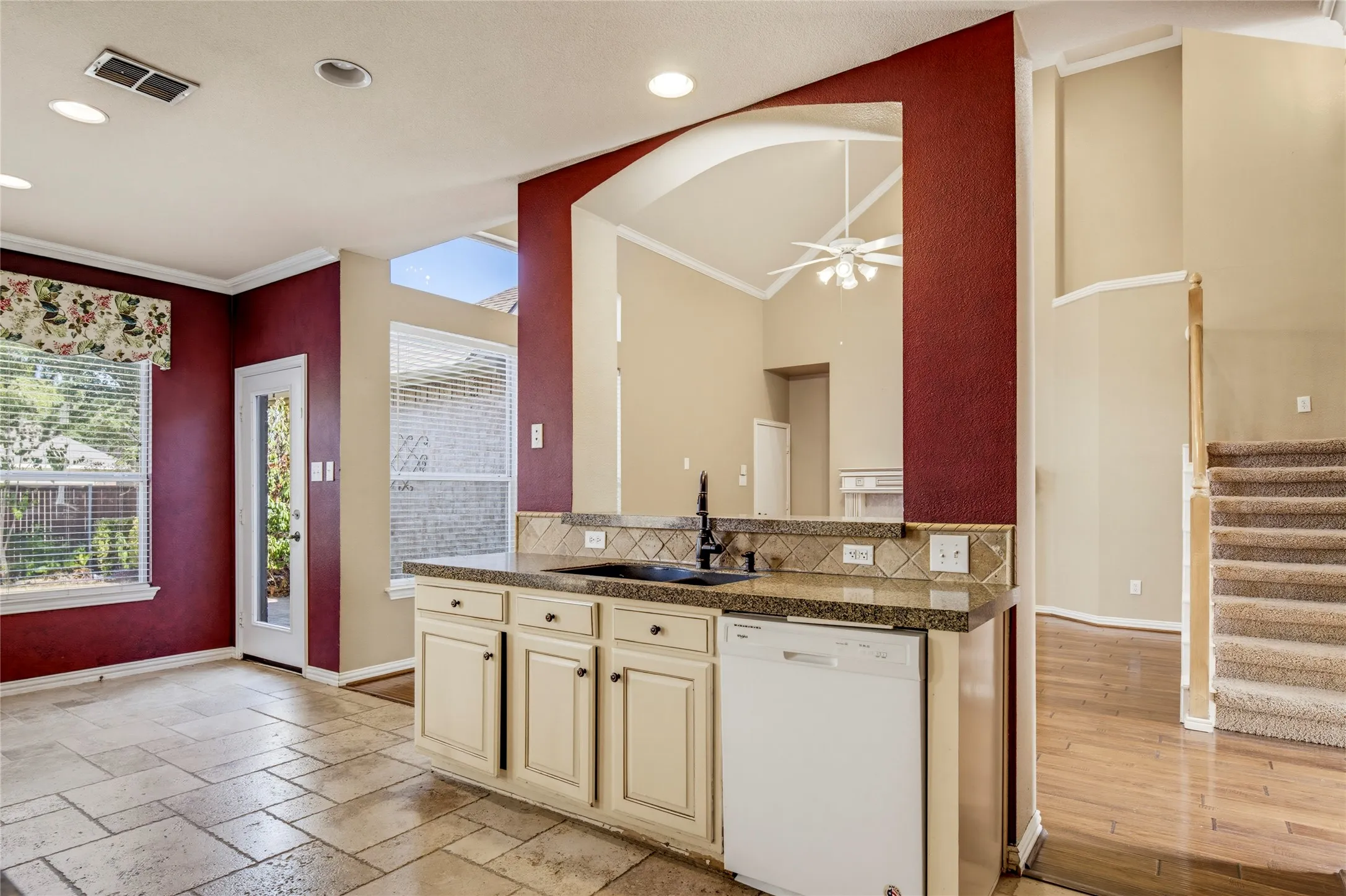 Kitchen featuring a built-in dishwasher, an undermount sink, and light-toned cabinetry
