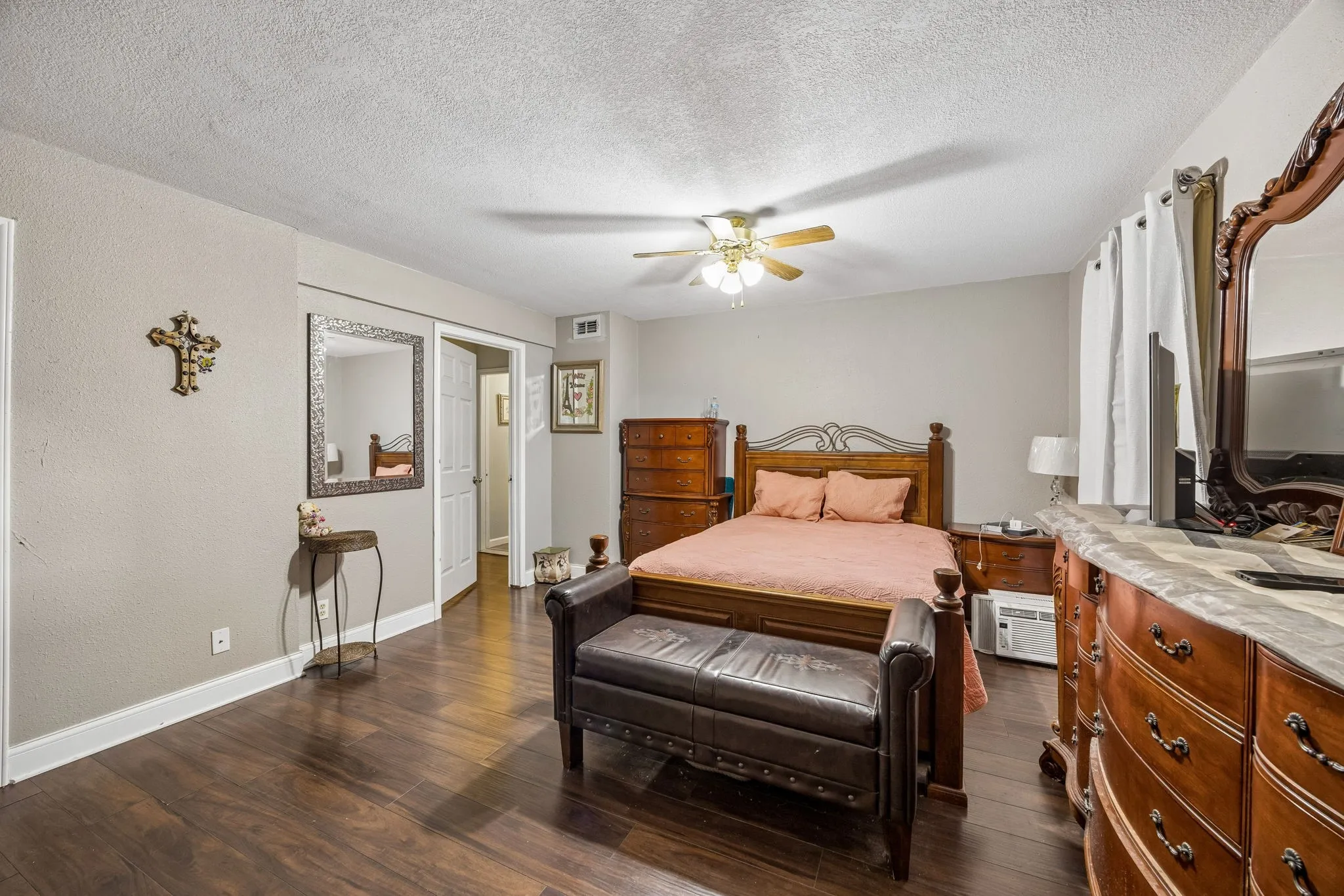 Wood-finish flooring, neutral wall tones, and a ceiling fan with integrated lighting