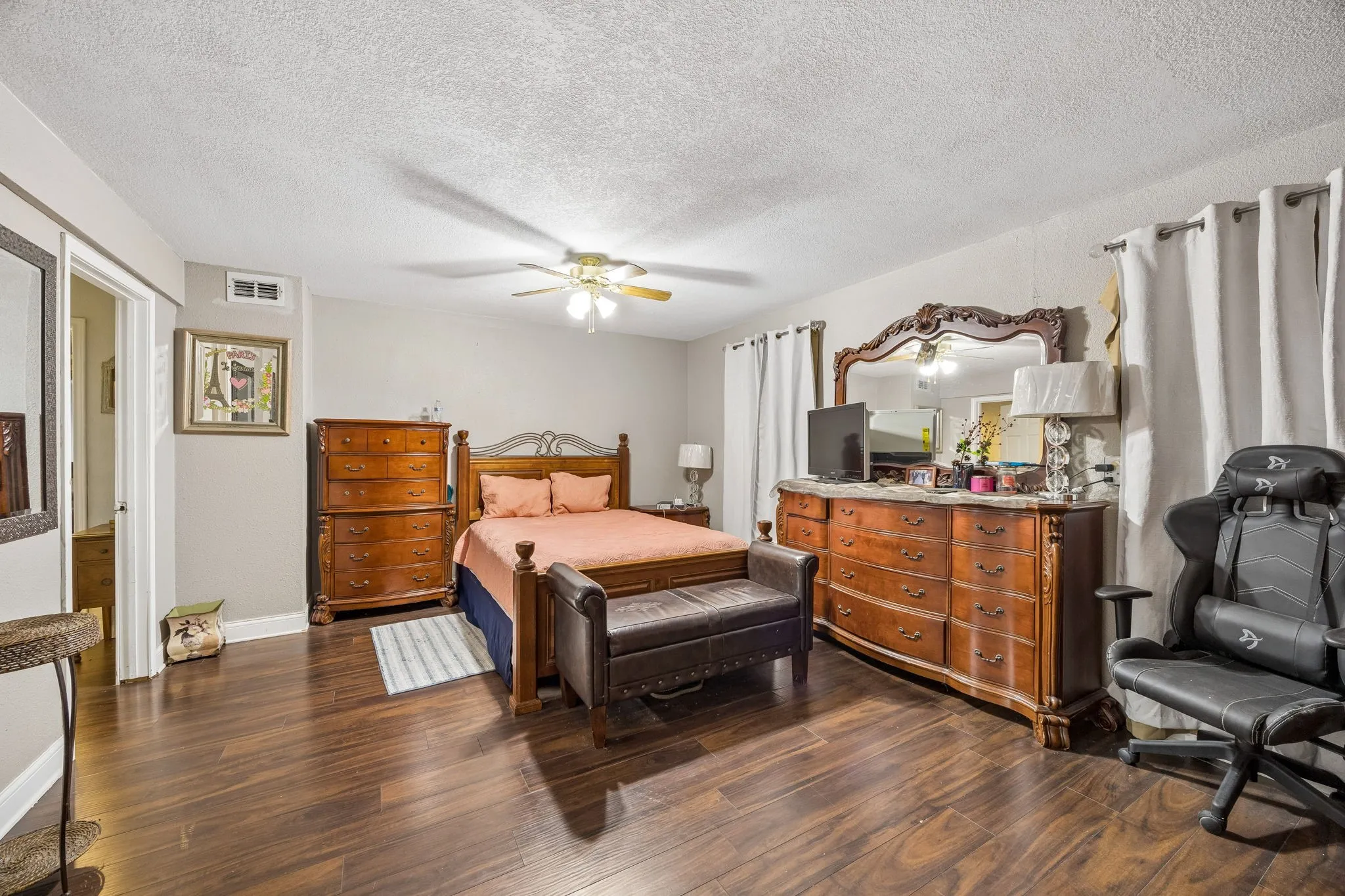 Wood-finish flooring throughout, ceiling fan with integrated lighting, and neutral wall tones
