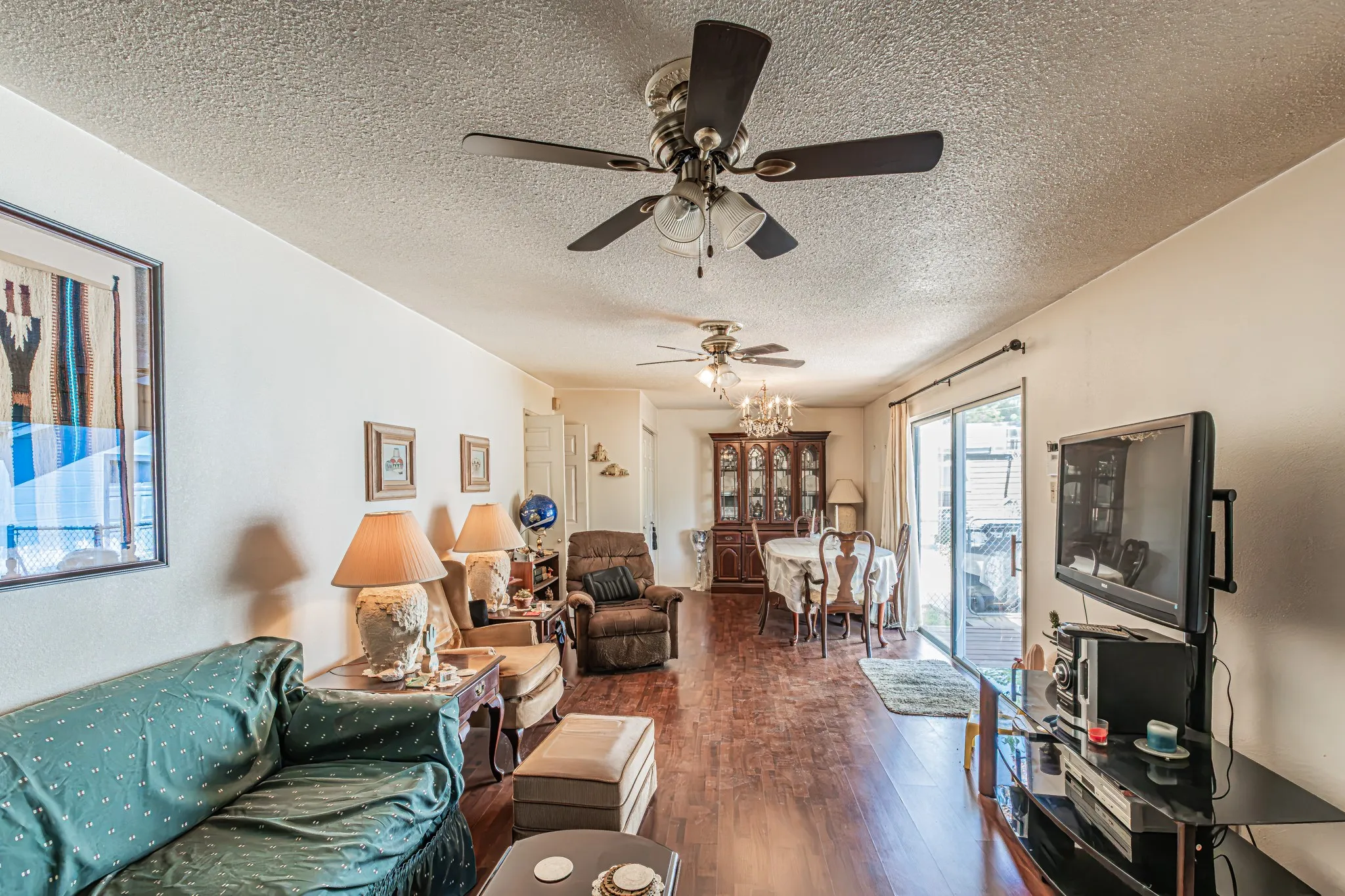 Hardwood-finish flooring throughout, ceiling fans, and an exposed aggregate patio