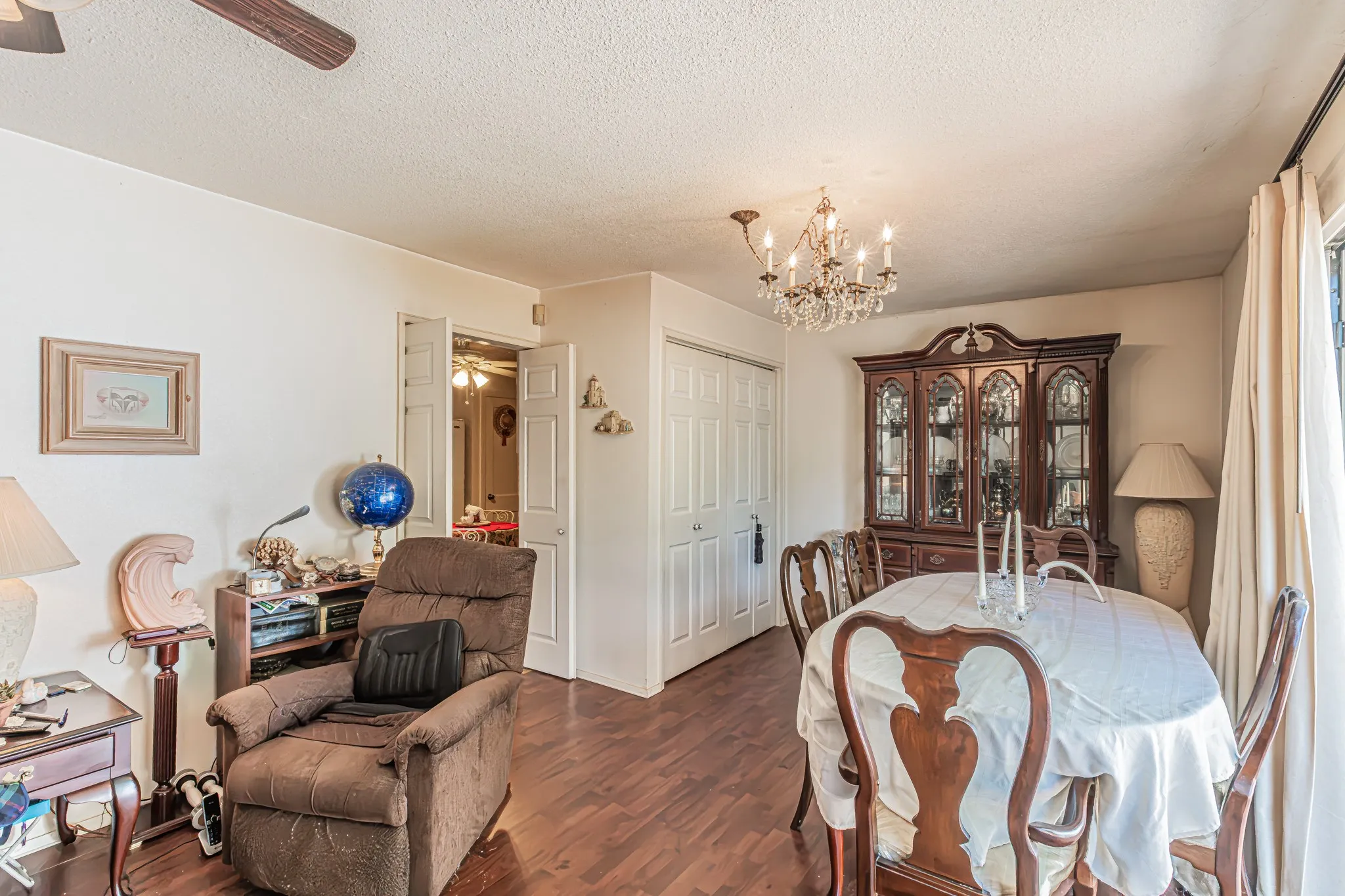 Wood-finish flooring throughout, with a classic chandelier and ceiling fan