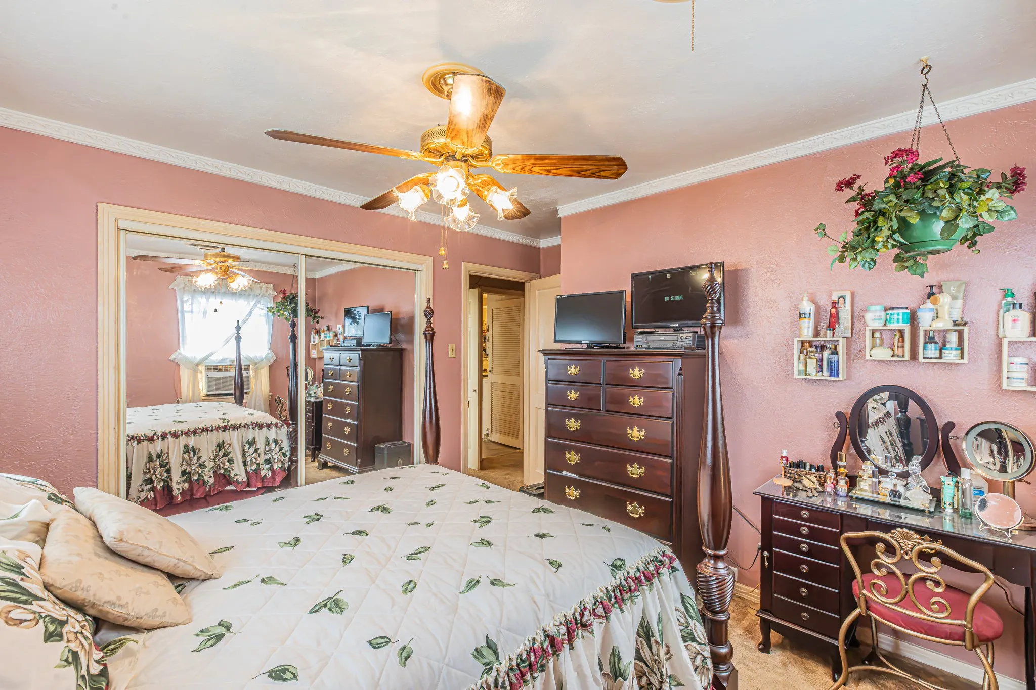 Ceiling fan with integrated lighting, mirrored sliding closet doors, crown molding, and wood-finish flooring