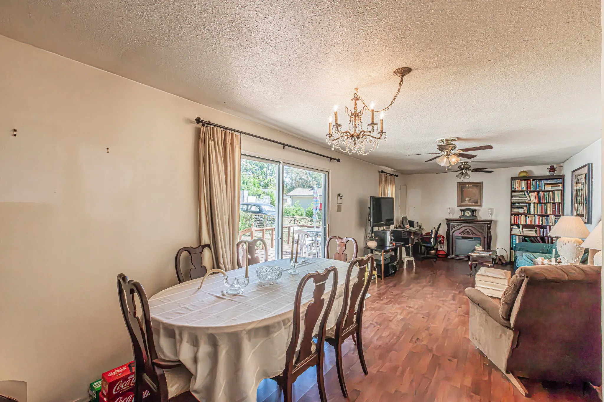 Hardwood-finish flooring, sliding glass door, fireplace with mantle, and a built-in bookcase
