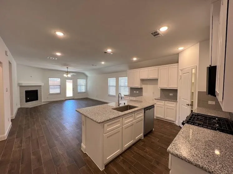Spacious kitchen with a center island, white cabinetry, and granite countertops