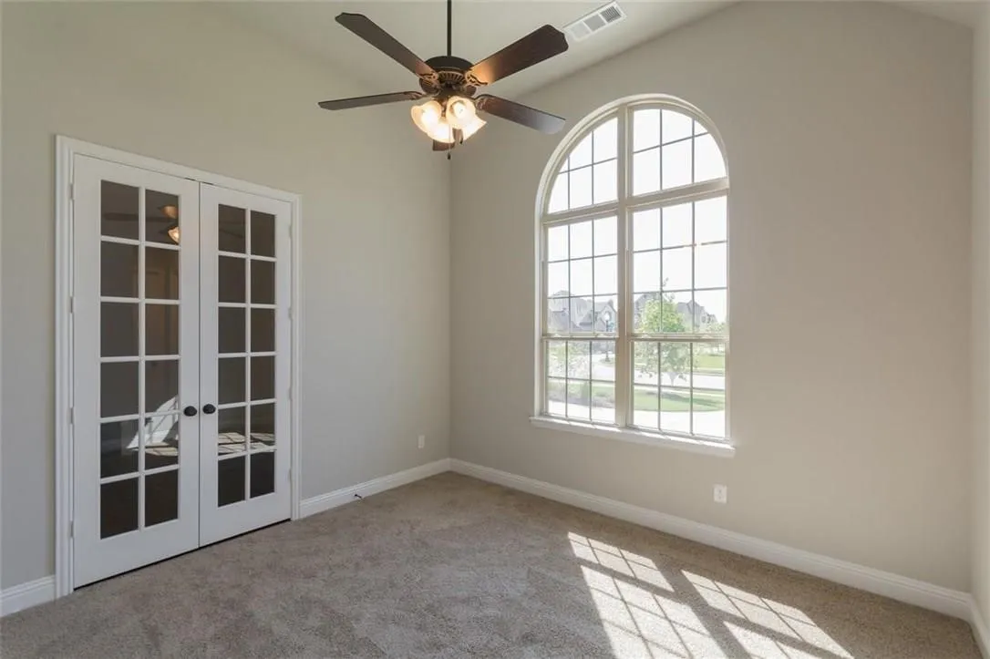 Study with ceiling fan, french doors, and carpet flooring