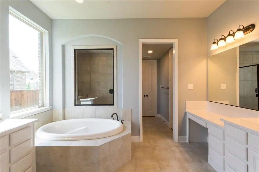 Bathroom with tile flooring, vanity with extensive cabinet space, tub plus walk in shower