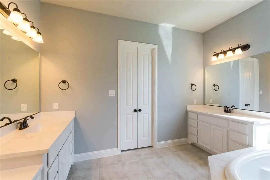 Bathroom with tile floors and dual vanities