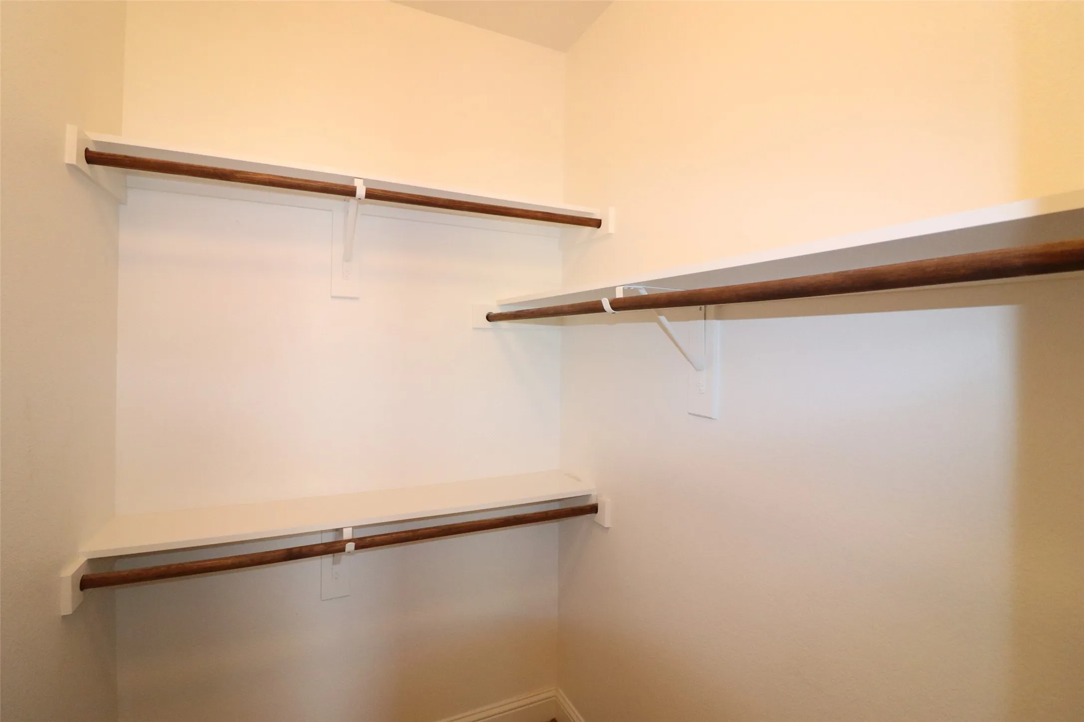 Built-in shelving with wood-finish hanging rods