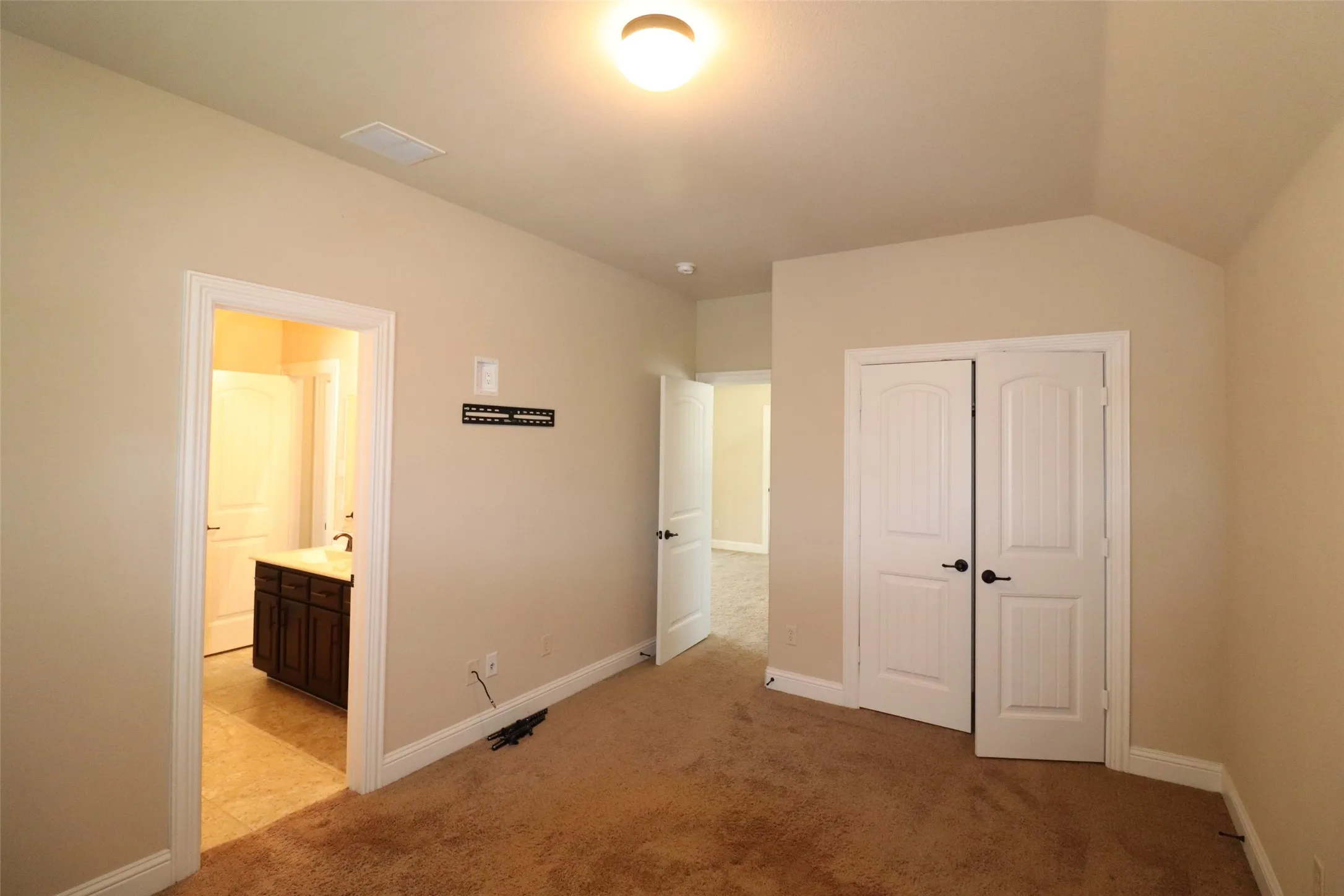 Carpeted room with a vaulted ceiling, recessed lighting, and white bi-fold closet doors