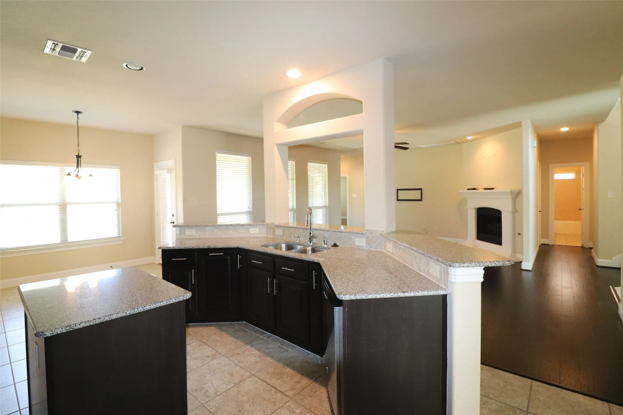 Kitchen with dark wood cabinetry, granite countertops, and stainless steel sink
