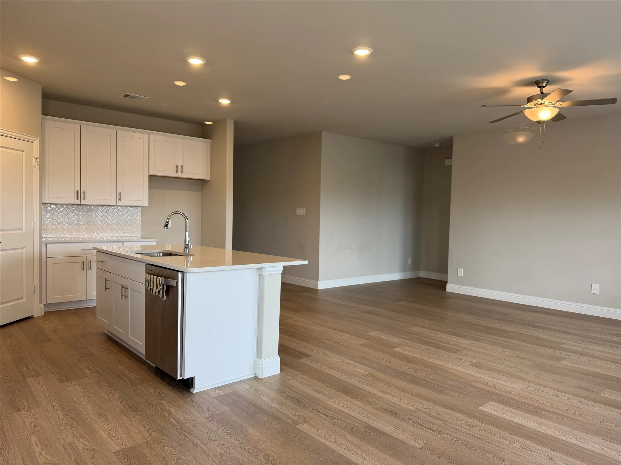 Open-concept living area featuring wood-finish flooring, recessed lighting, and a ceiling fan
