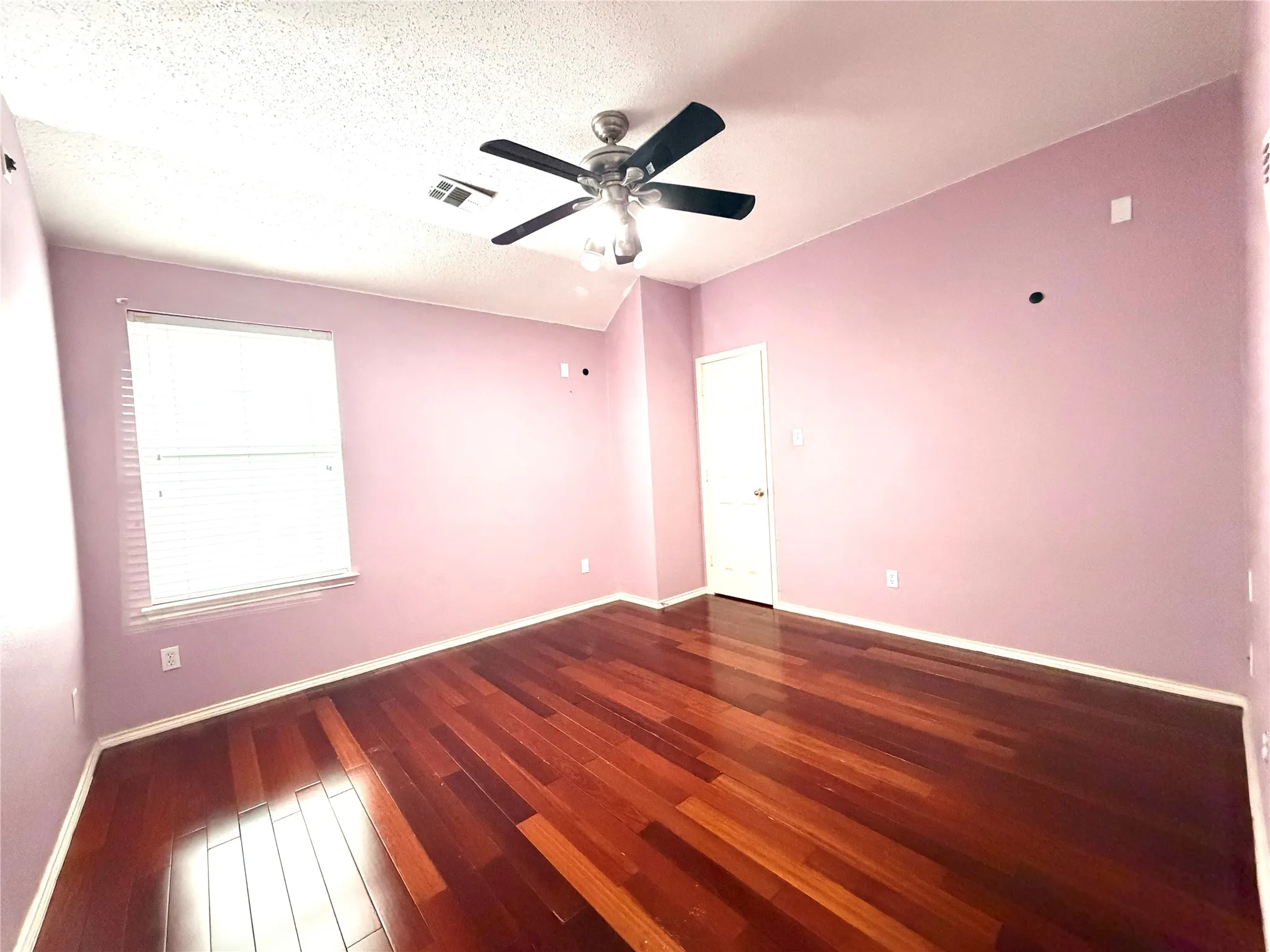 Wood-finish flooring, ceiling fan with integrated lighting, and a window with blinds