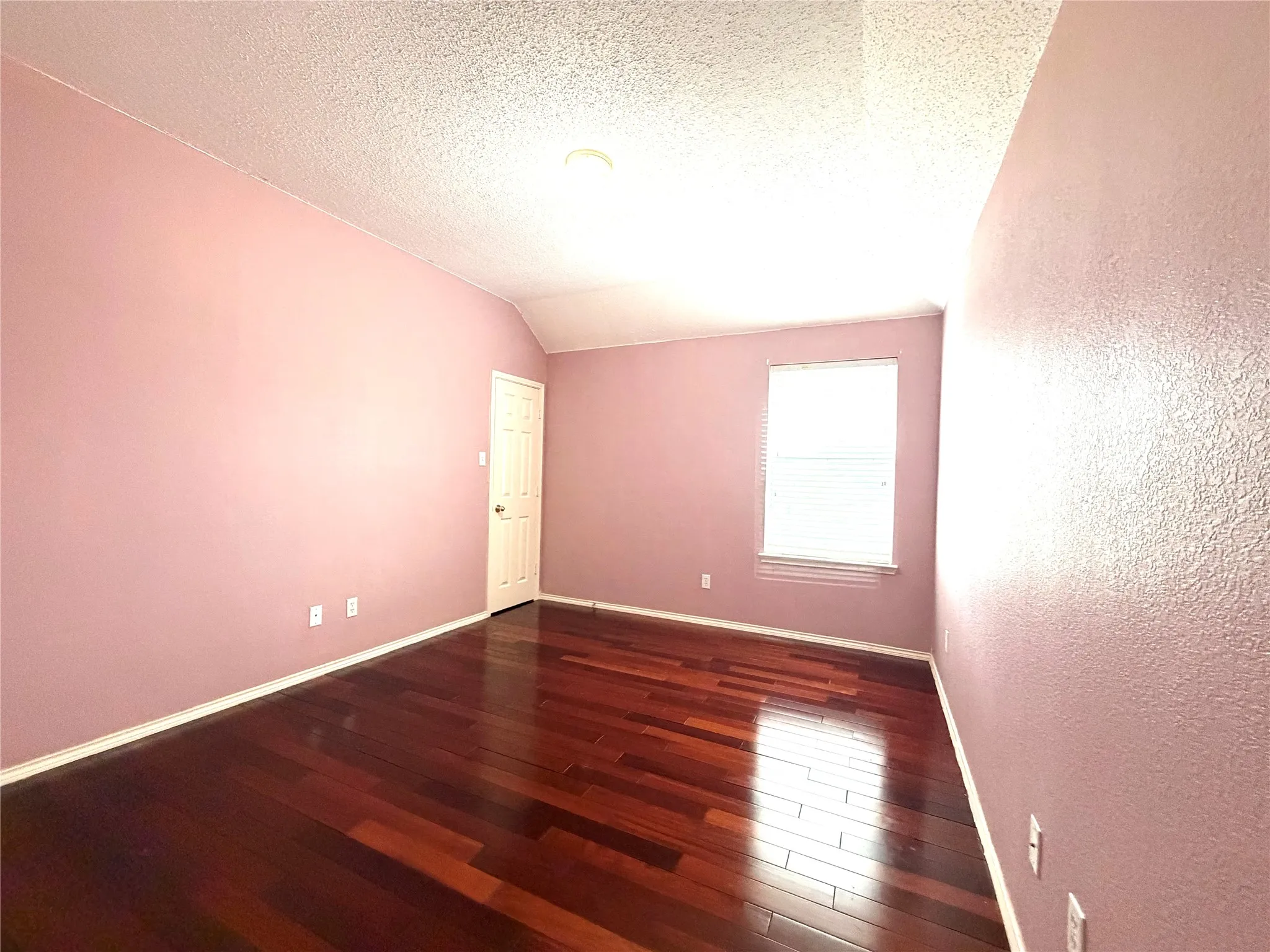 Rich wood-finish flooring, vaulted ceiling, and recessed lighting