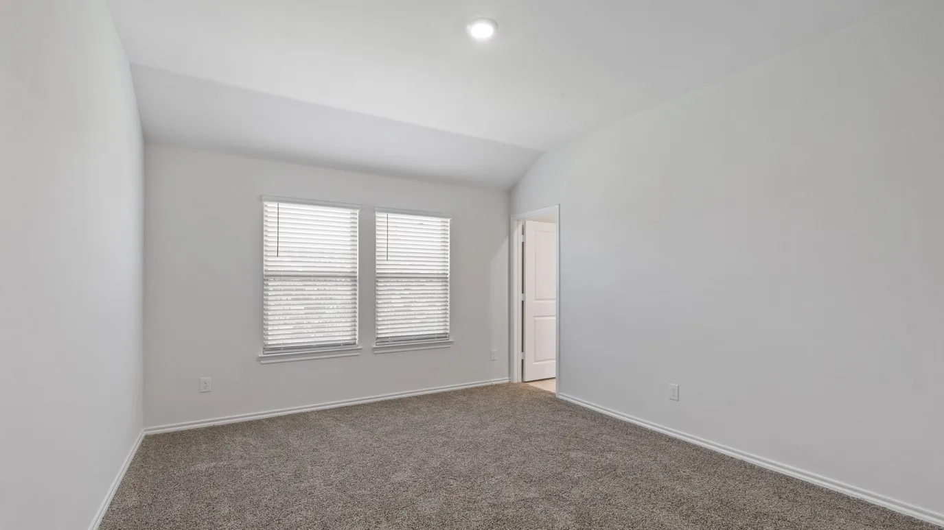 Carpeted room featuring white walls, a vaulted ceiling, recessed lighting, and dual windows with blinds