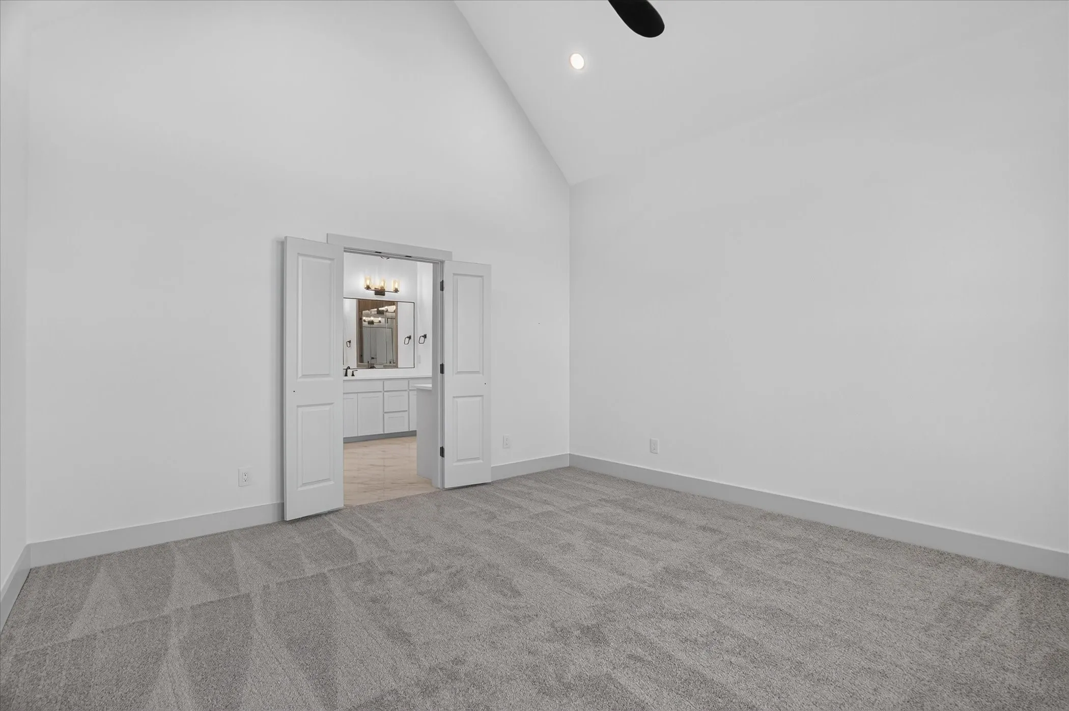 Vaulted ceiling, recessed lighting, and carpeted flooring