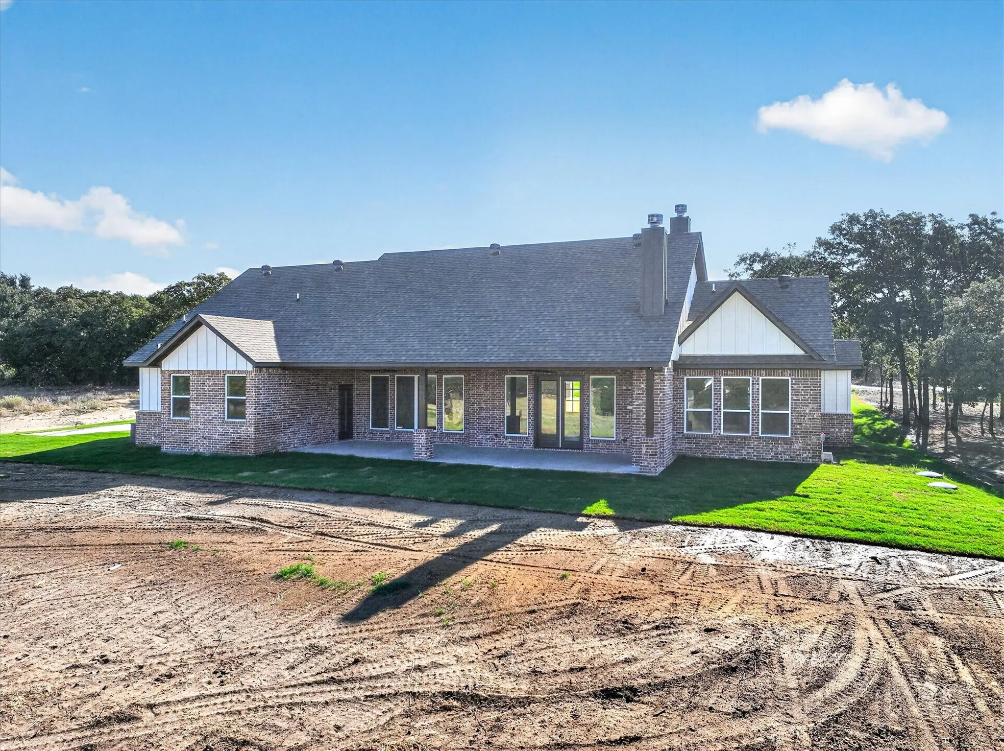 Brick exterior with white siding accents and a dark shingle roof