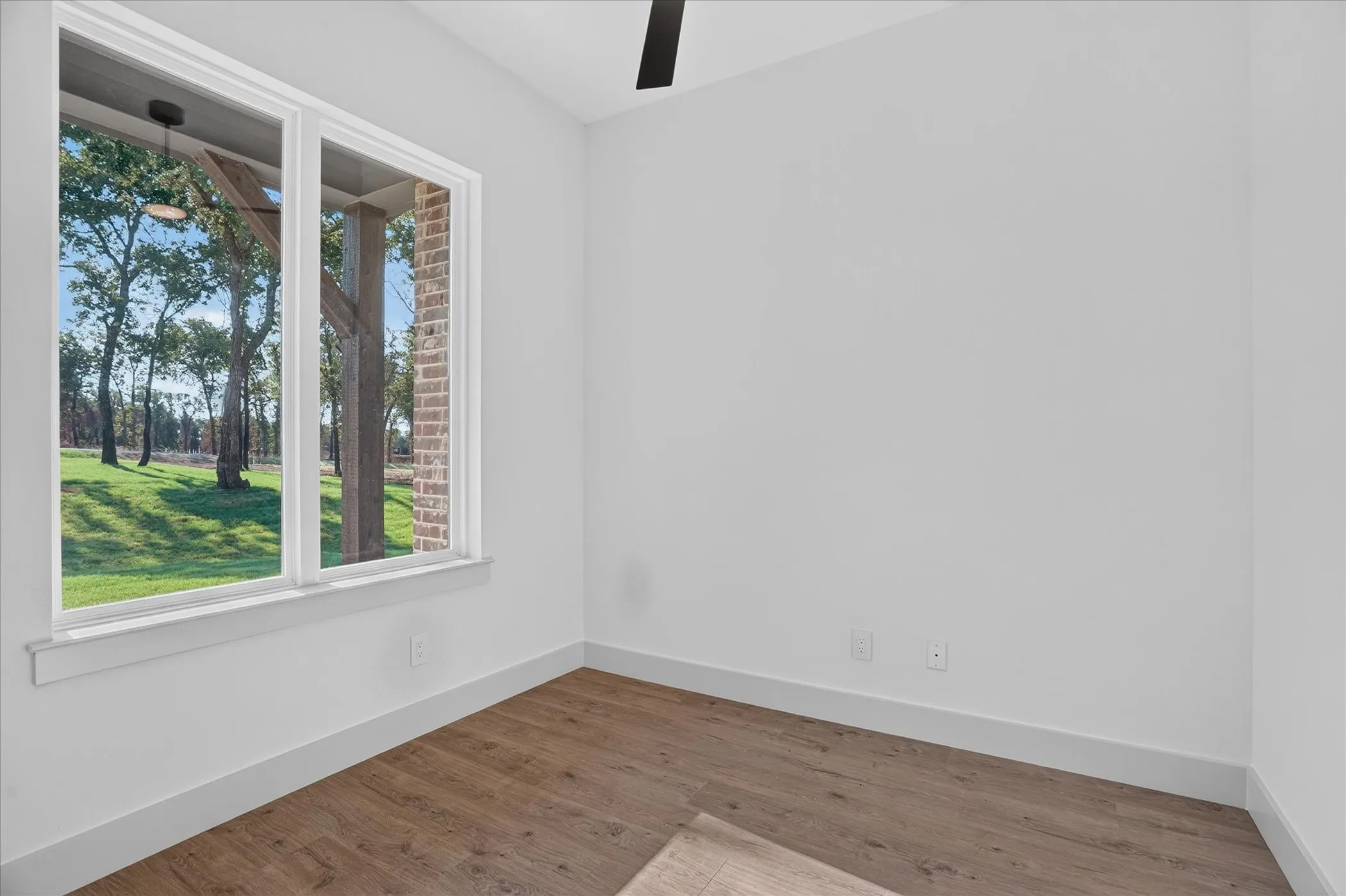 Large dual-pane window, wood-finish flooring, recessed lighting, and a ceiling fan