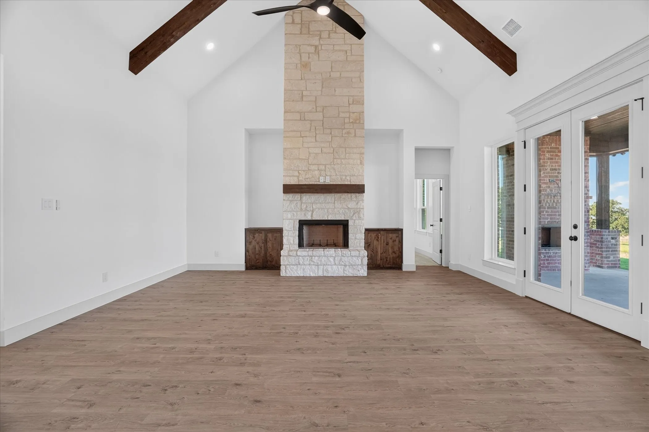 Vaulted ceiling with exposed wood beams and ceiling fan