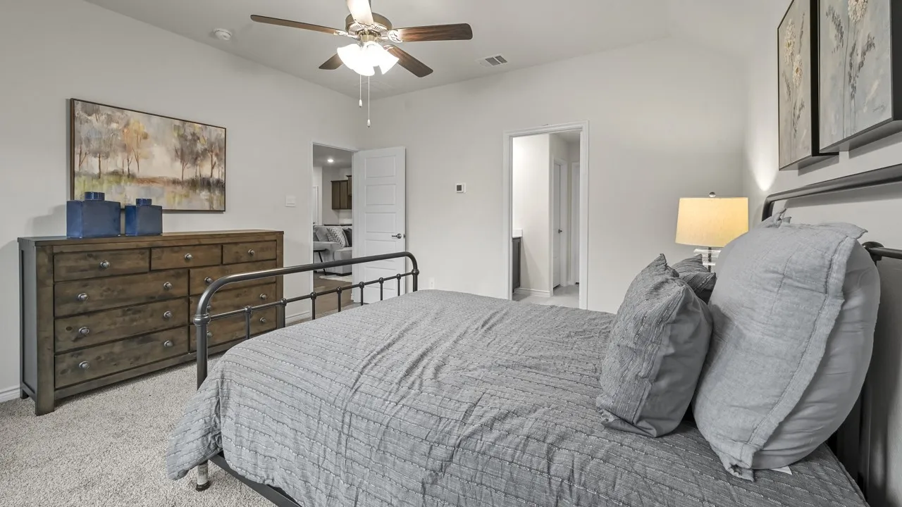 Vaulted ceiling, ceiling fan, neutral wall paint, carpet flooring, interior doorway