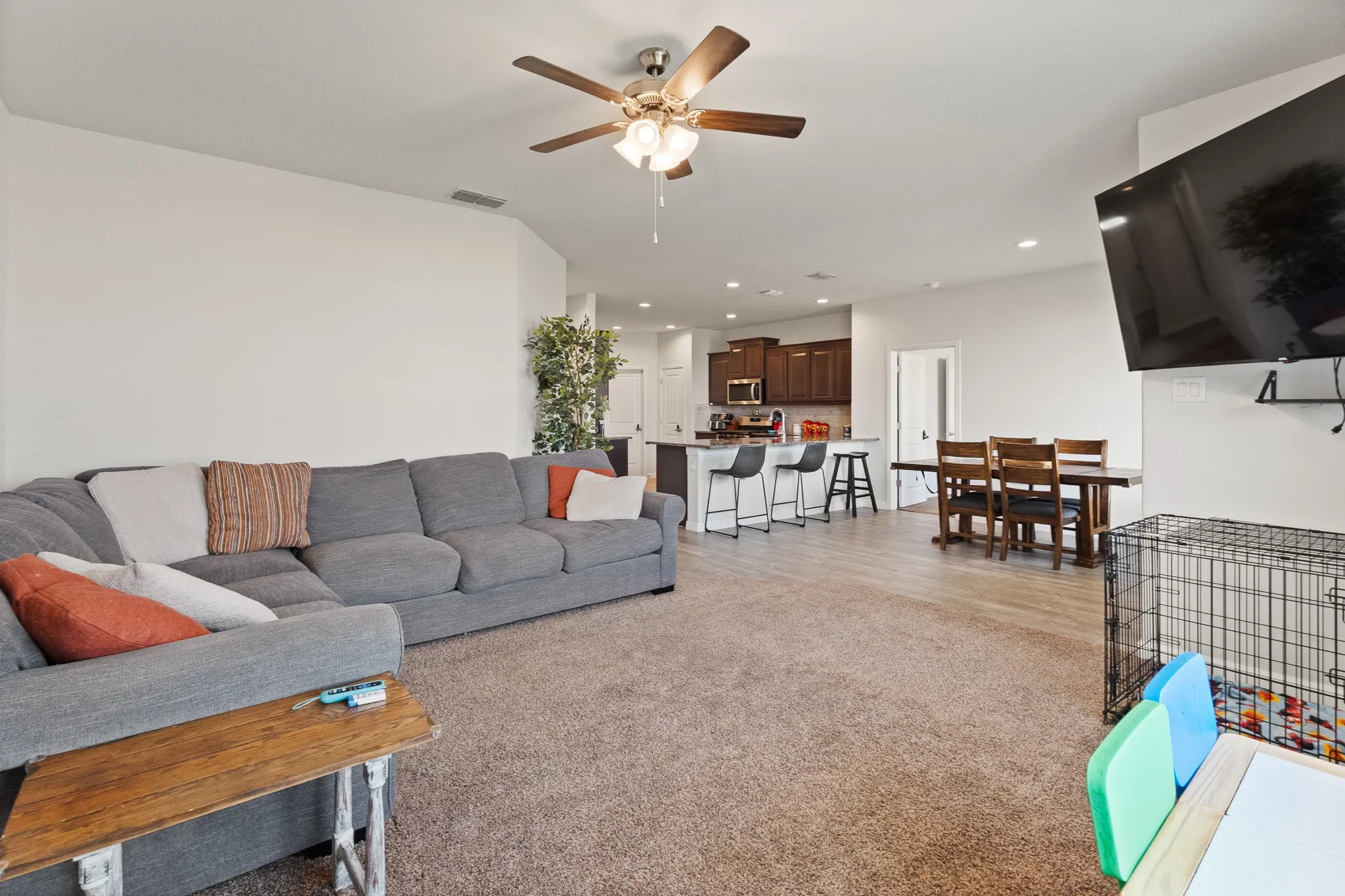 Open-concept living space with a ceiling fan, recessed lighting, and wood-finish flooring