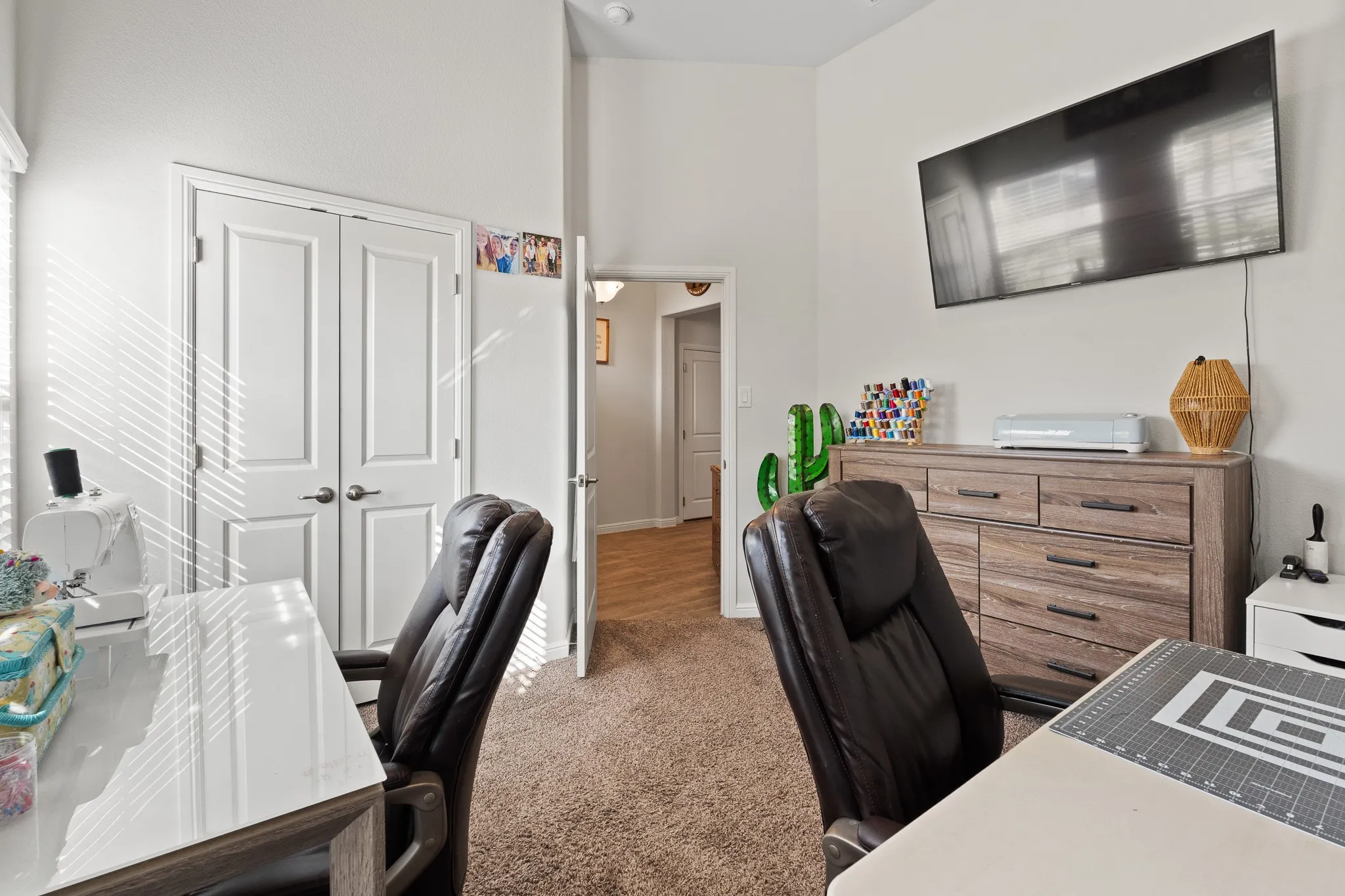 Vaulted ceiling with recessed lighting, double panel doors, and wood-finish flooring in the doorway