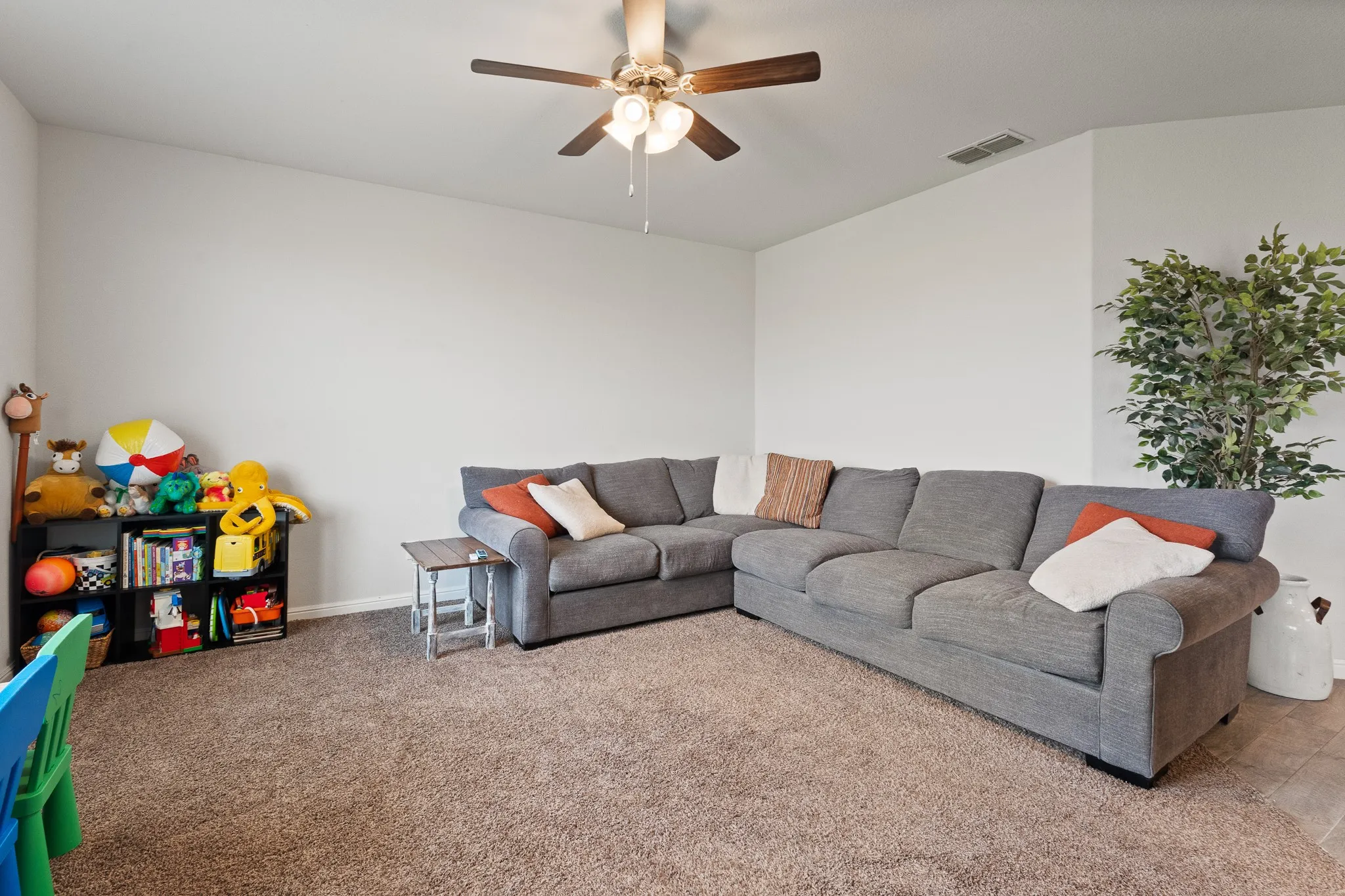 Carpeted flooring, neutral wall tones, and a ceiling fan with integrated lighting