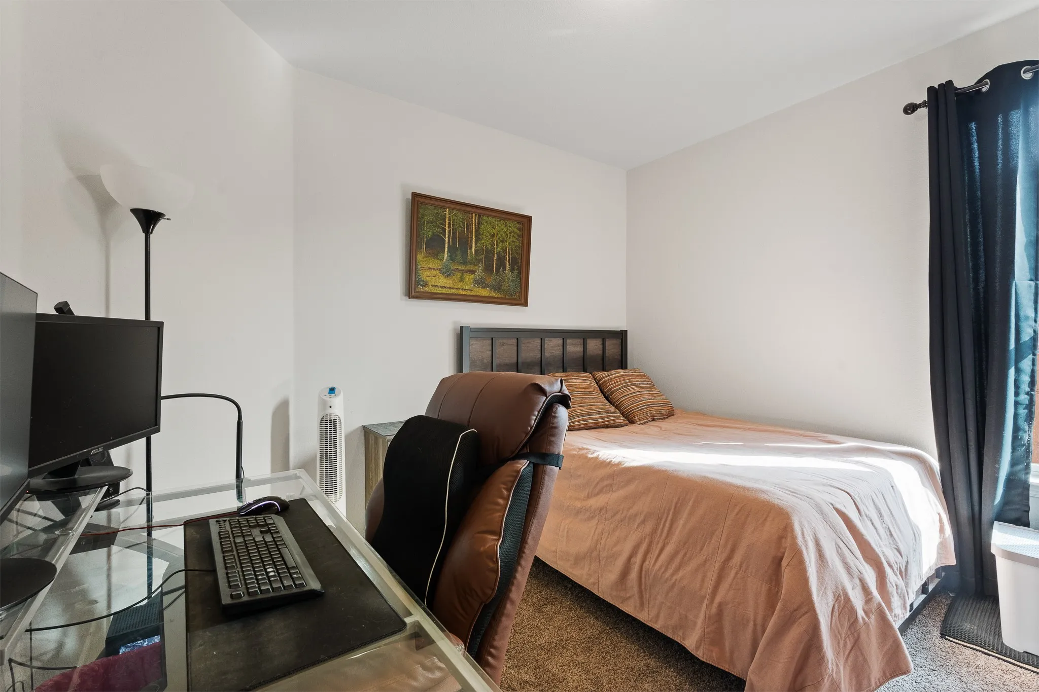 Neutral wall paint, window with dark curtains, and wood-finish​​‌​​​​‌​​‌‌​‌‌​​​‌‌​‌​‌​‌​​​‌​​ headboard