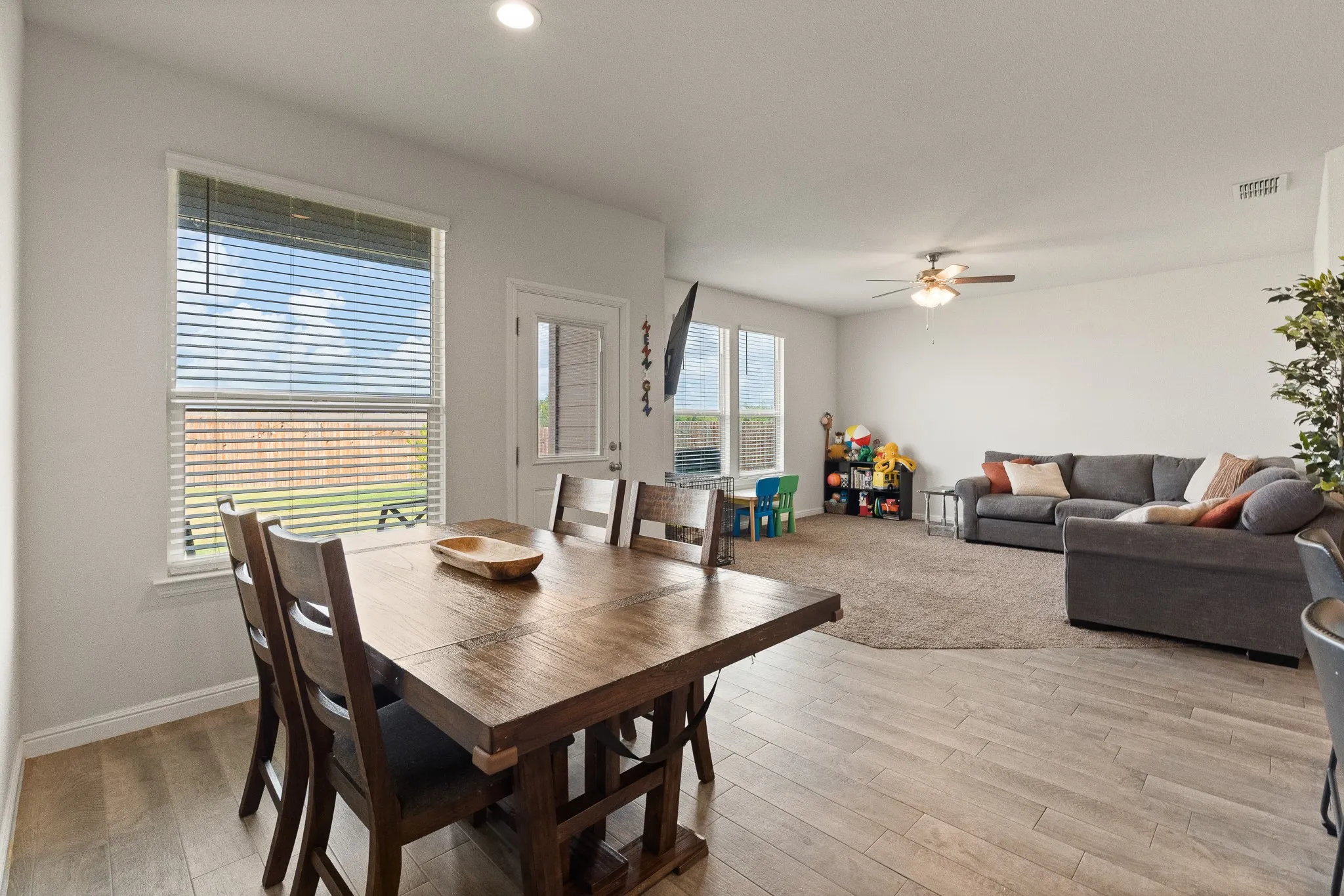 Open-concept living space featuring wood-finish flooring, recessed lighting, and a ceiling fan
