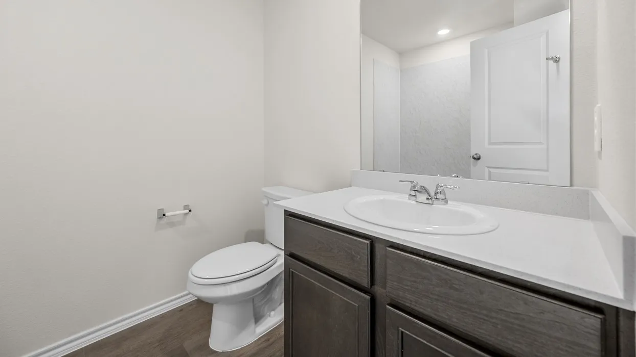 Contemporary bathroom featuring a wood-finish vanity with dual drawers, white quartz countertop, and chrome faucet