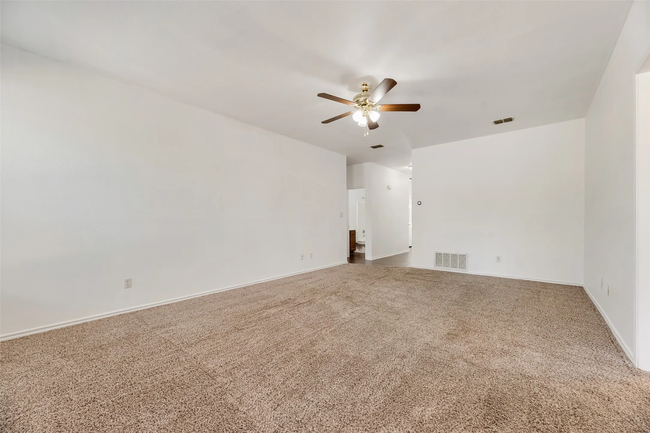 Spacious room with plush carpet flooring and white walls