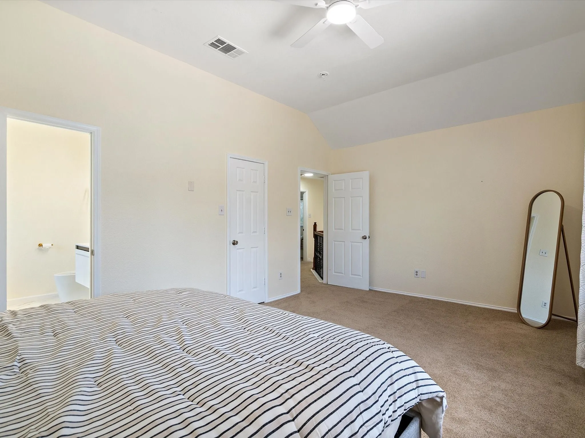Bedroom featuring lofted ceiling, light colored carpet, and a ceiling fan