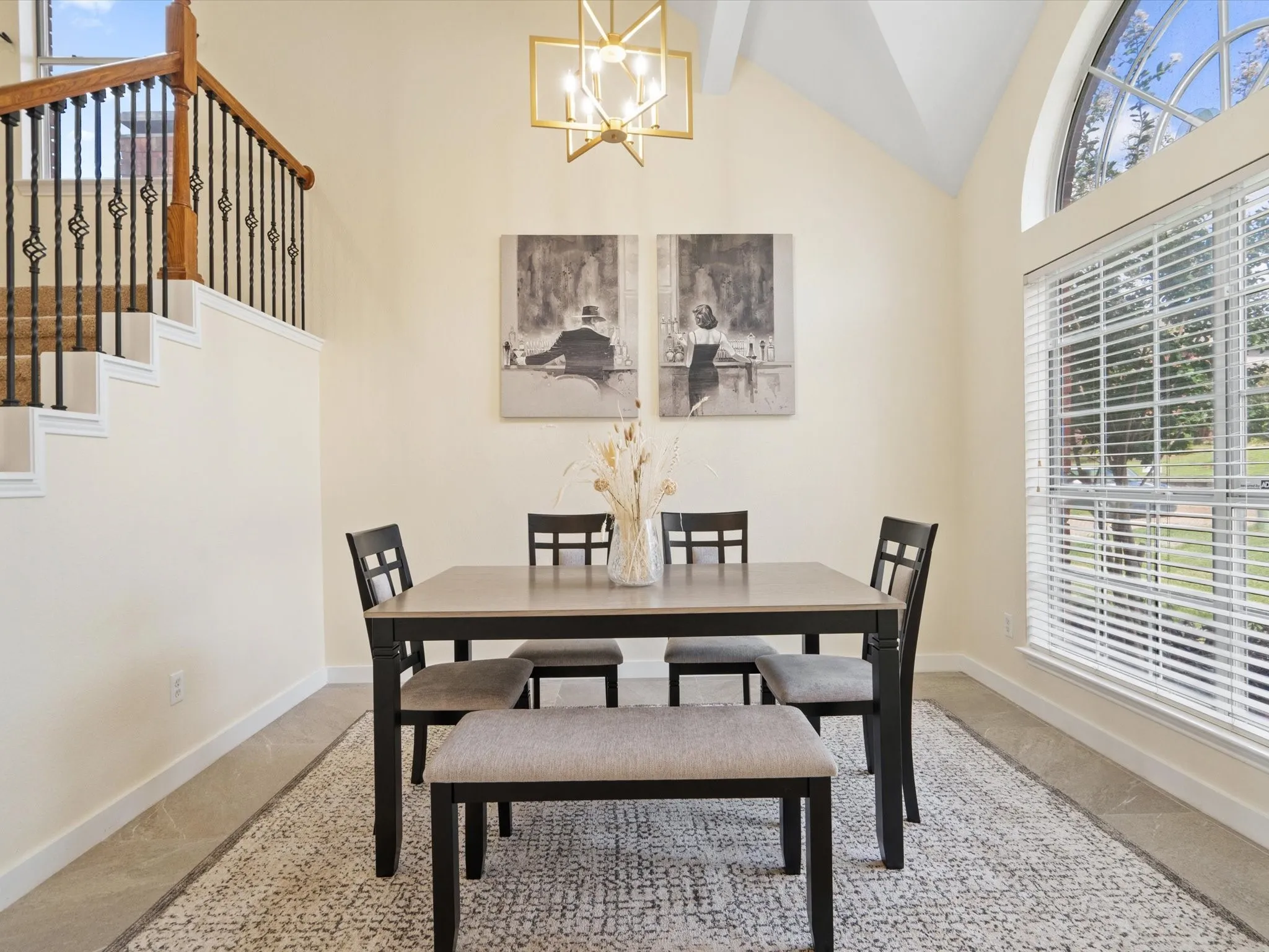 Dining room with high vaulted ceiling, a chandelier, and stairway