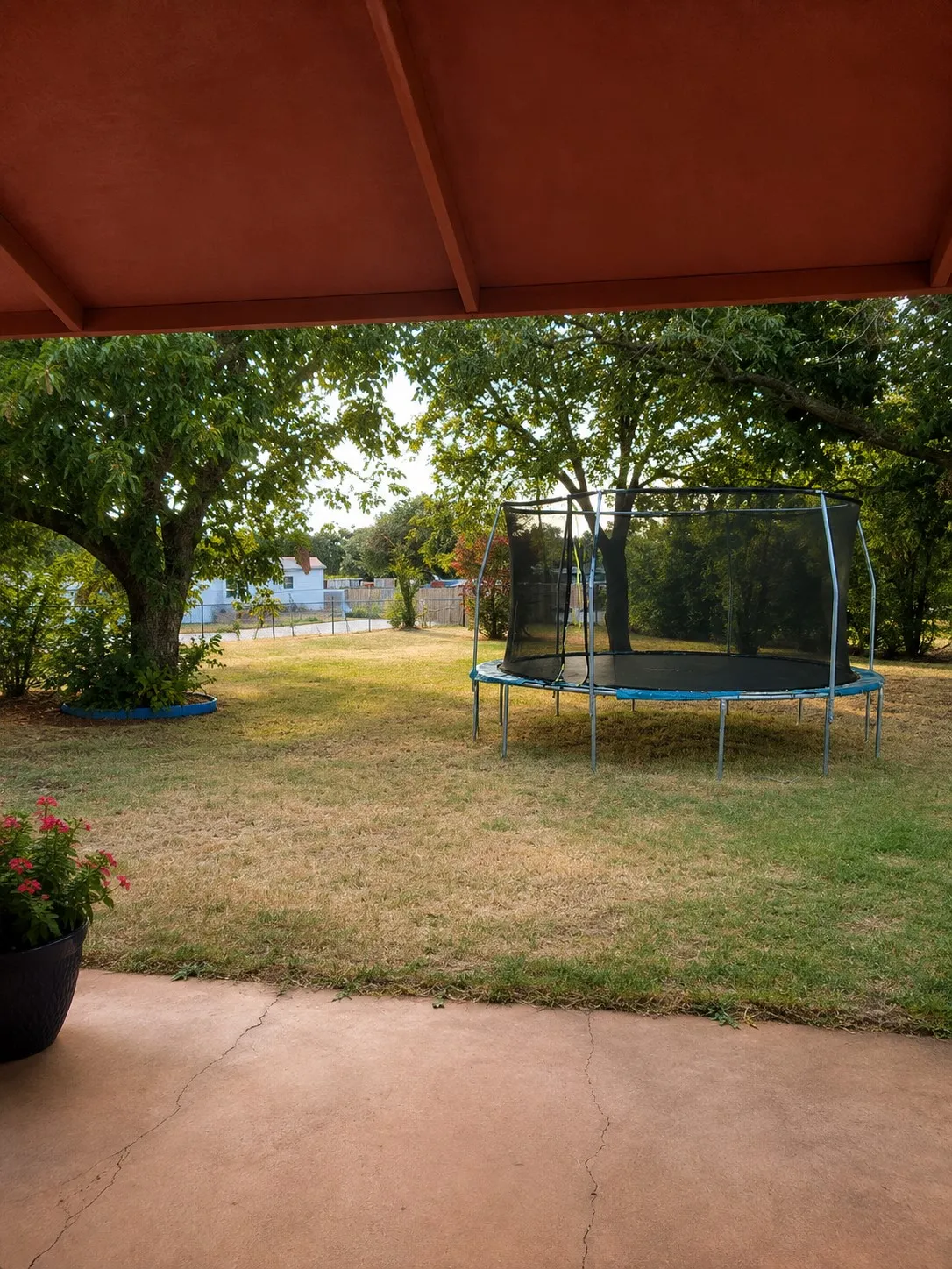 Expansive backyard with a covered patio and mature trees