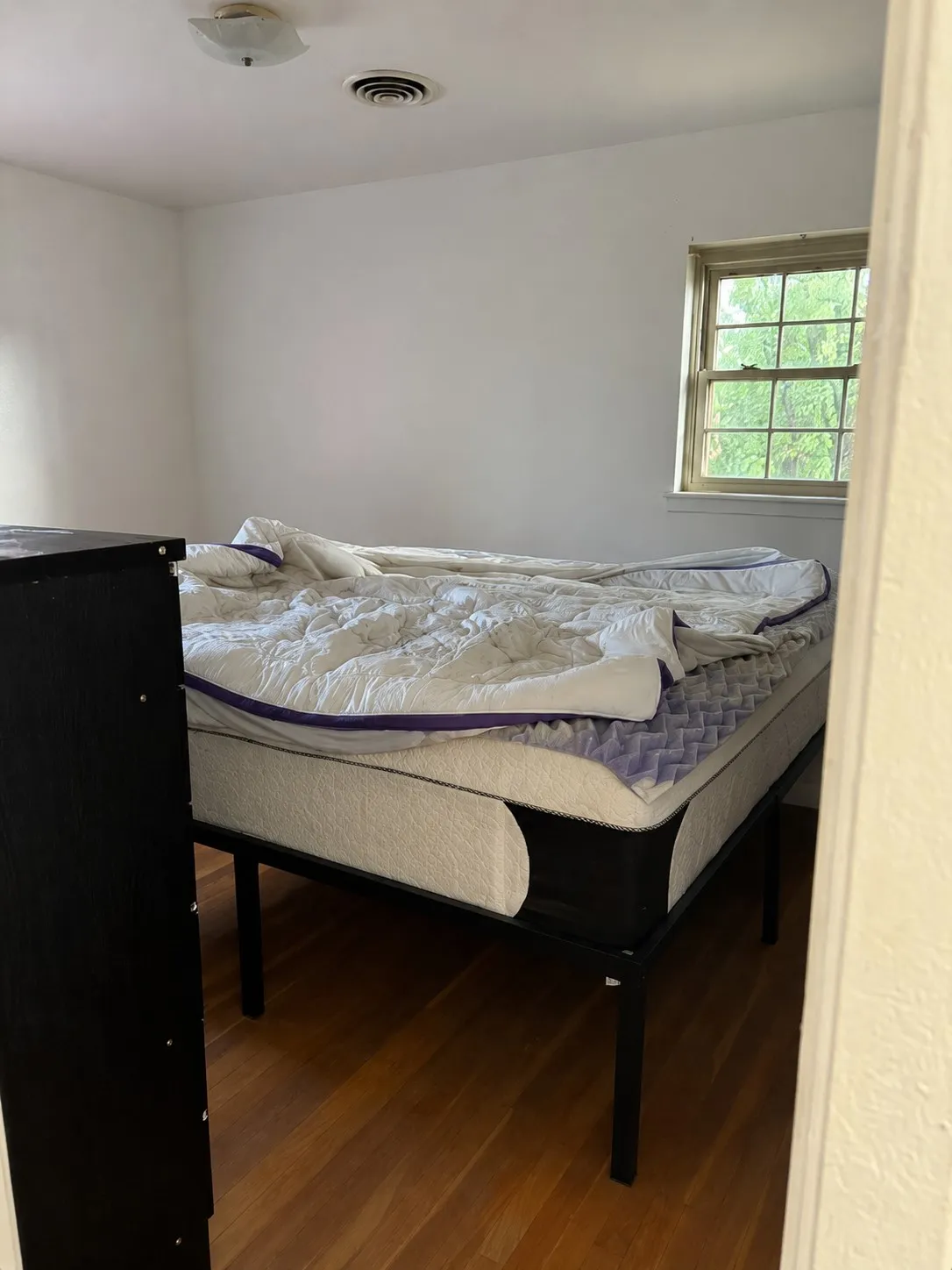 Hardwood flooring, white walls, ceiling-mounted light fixture, recessed ceiling vent, and a window with grid​​‌​​​​‌​​‌‌​‌‌​​​‌‌​‌​‌​‌​​​‌​​ panes