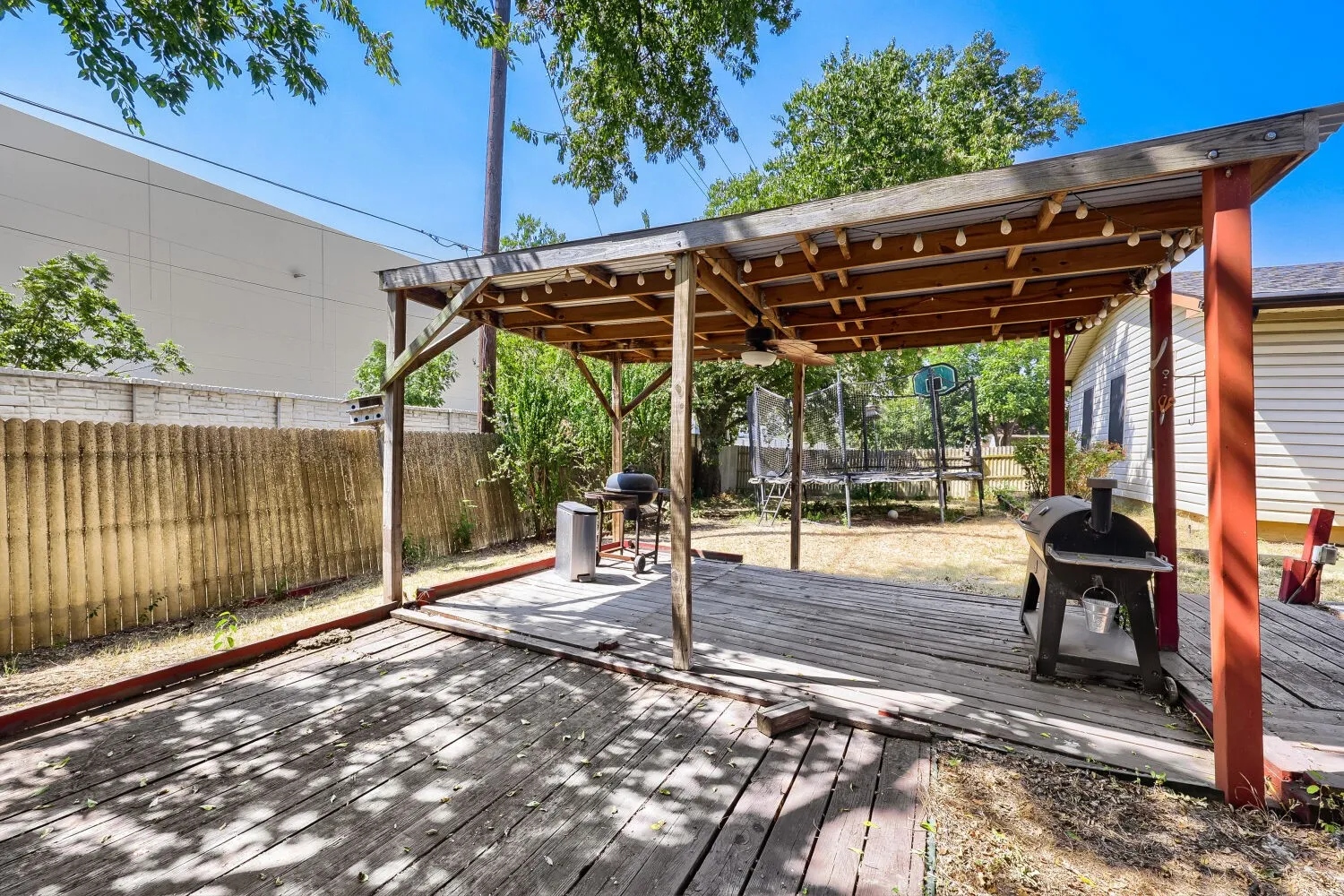 Expansive wooden deck with a covered pergola structure