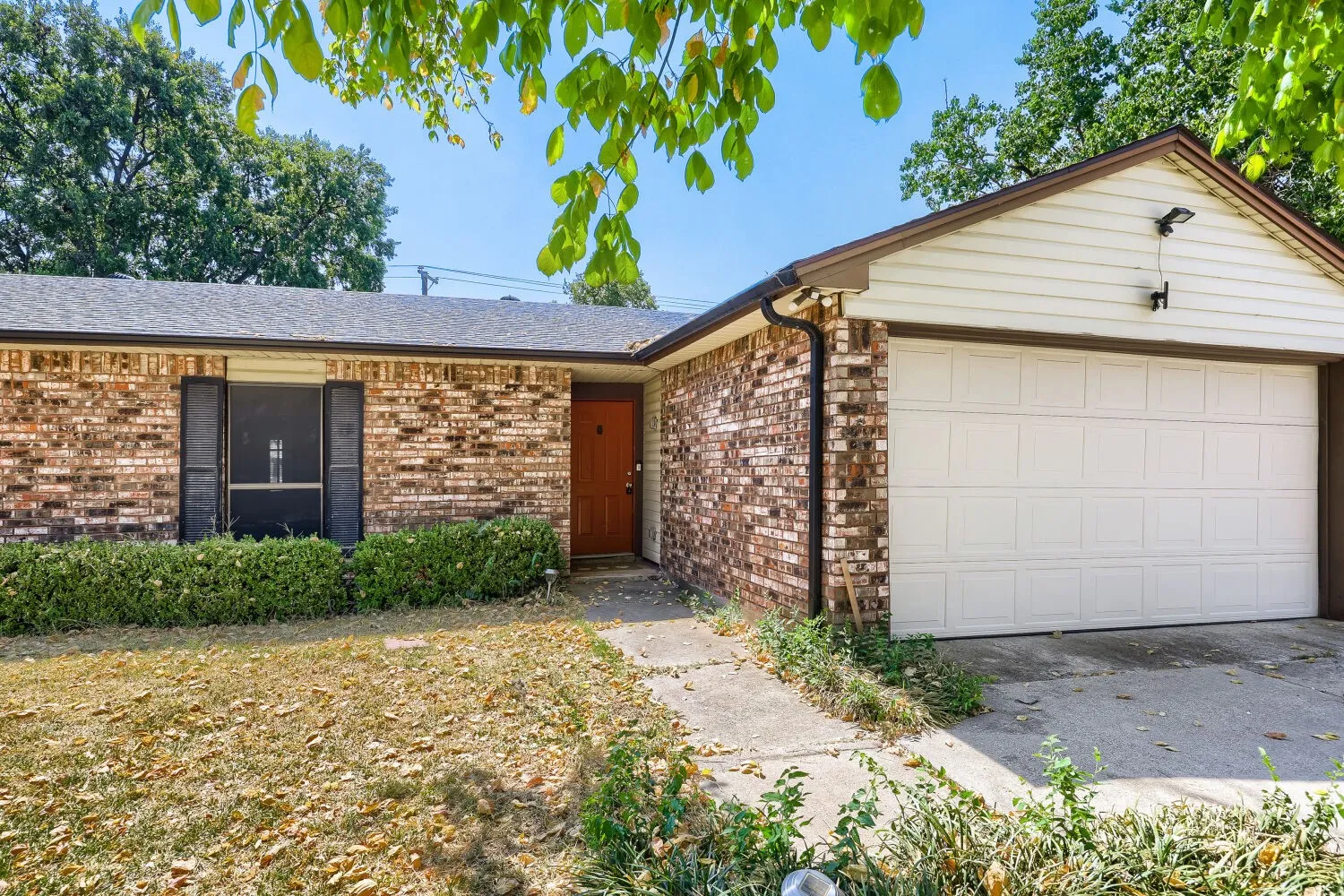 Brick exterior with contrasting light siding on the garage gable