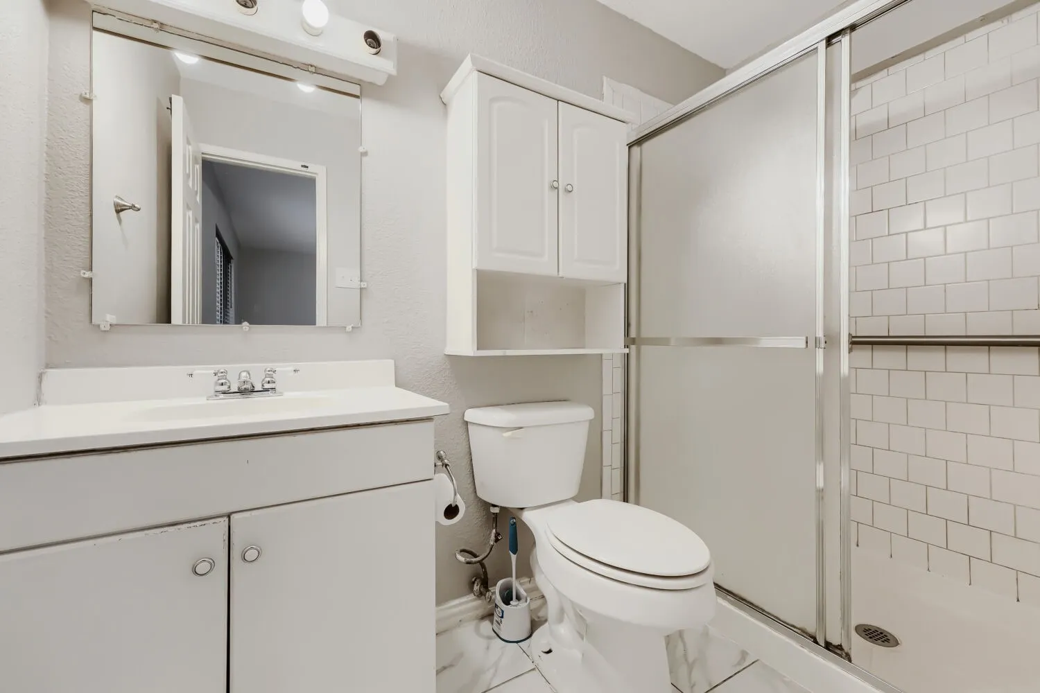 White subway tile shower surround with a sliding glass enclosure