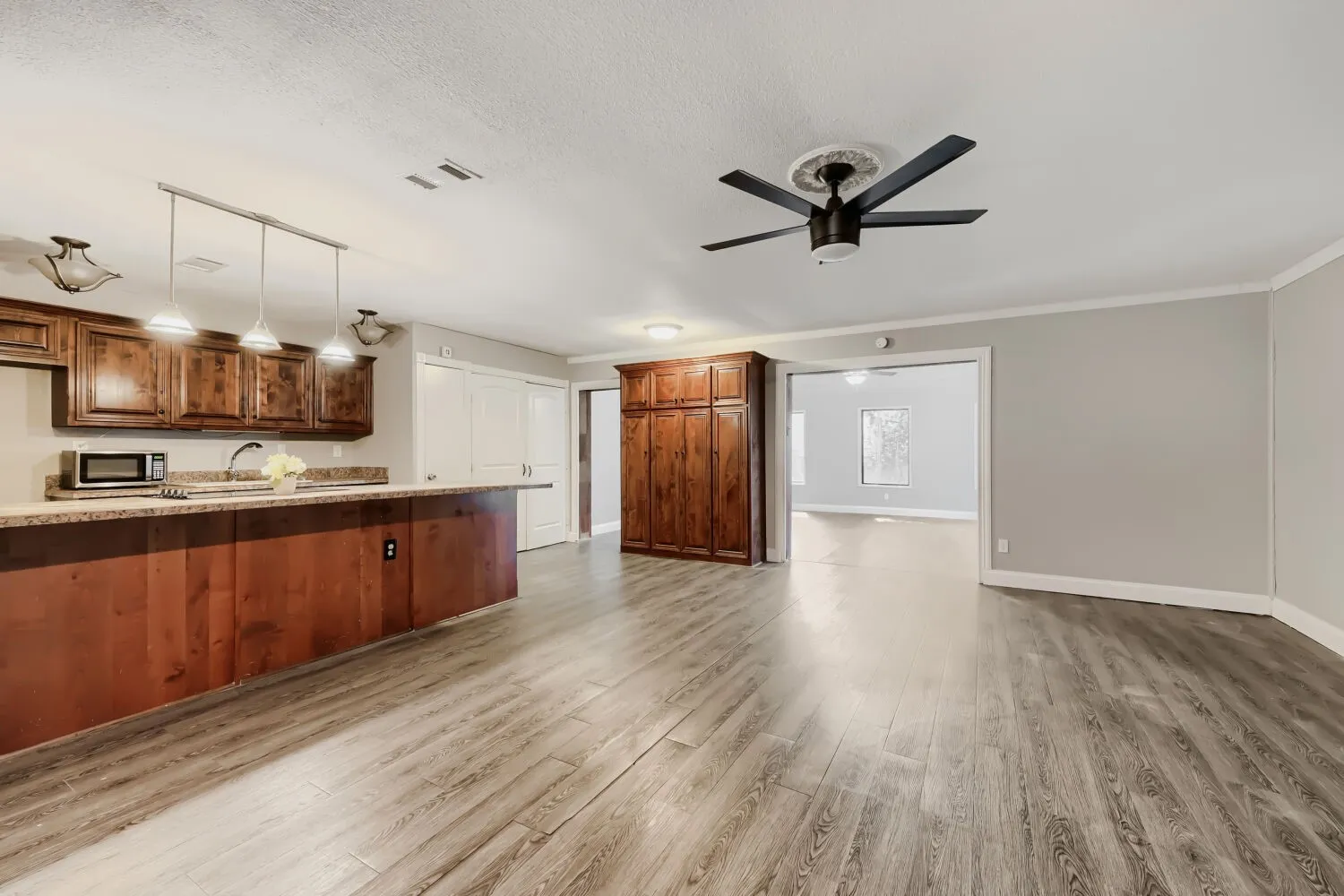 Wood-finish flooring, recessed lighting, and a ceiling fan with a medallion