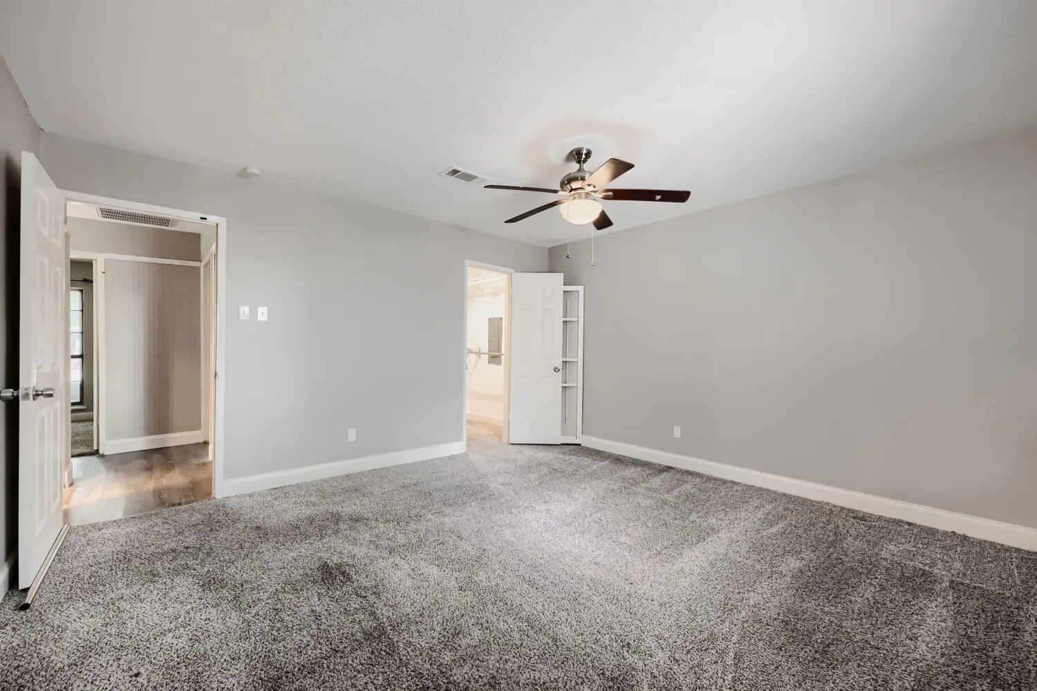 Gray wall paint, gray carpet flooring, ceiling fan, and white trim