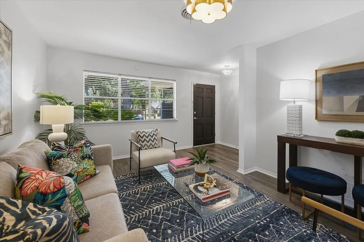 Decorative lighting, wood-finish flooring, white walls, and a prominent window with blinds