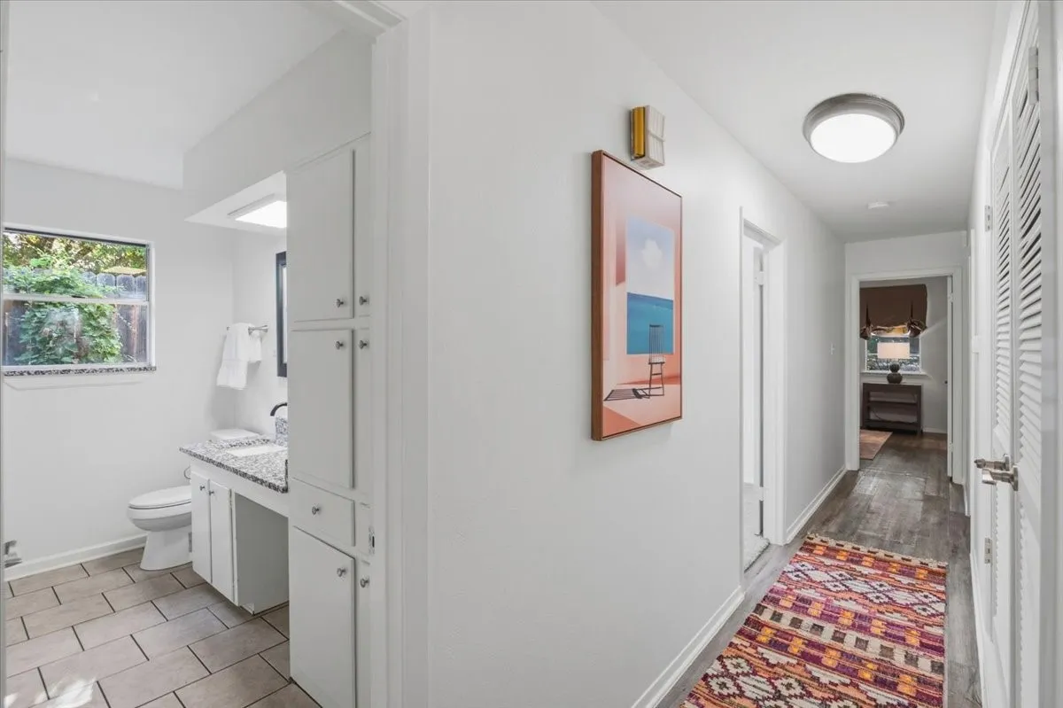White cabinetry with brushed nickel hardware, speckled countertop, and tiled flooring