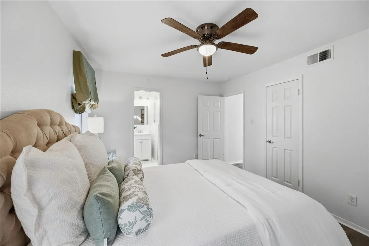 Ceiling fan, white paneled doors, and light-toned walls