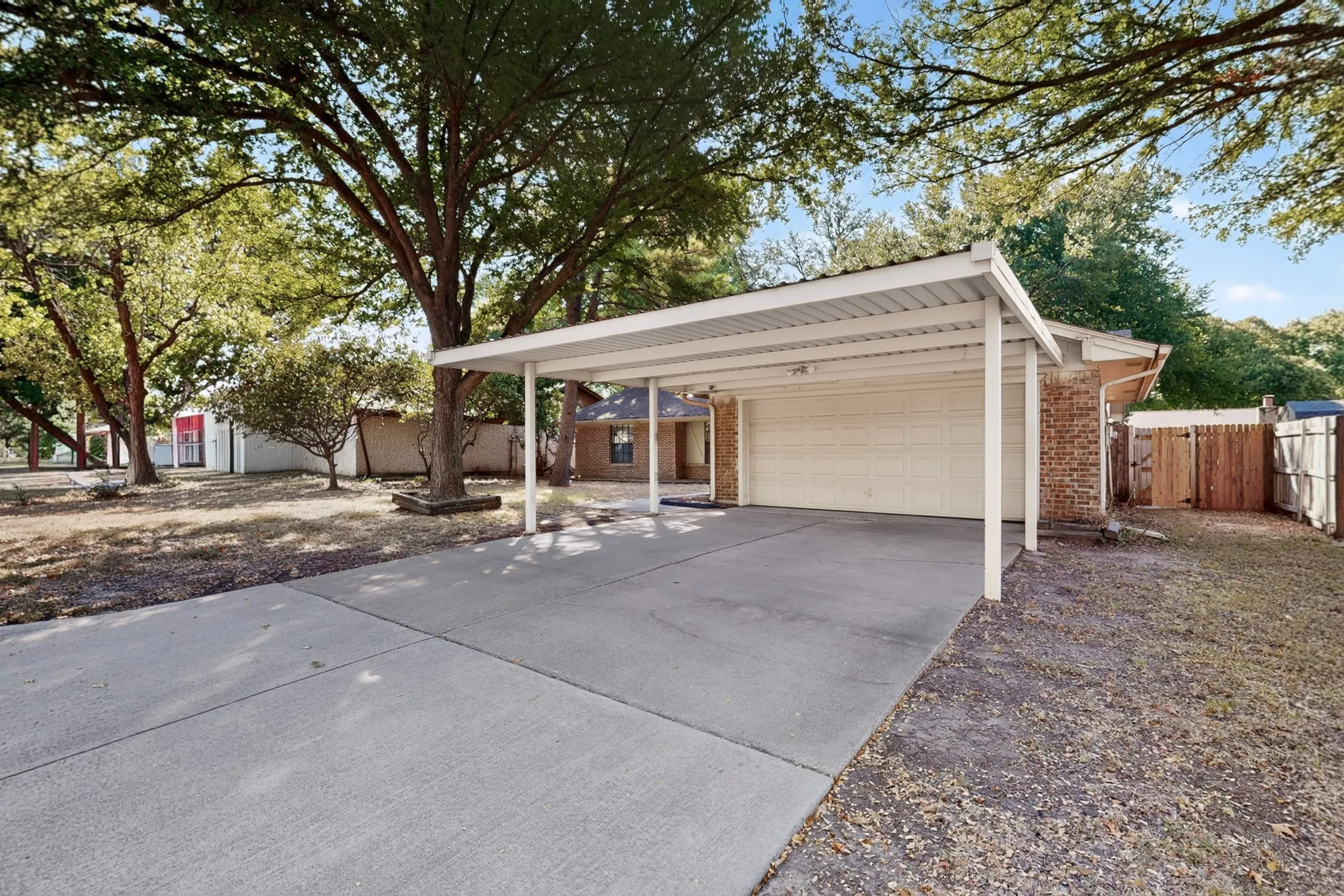 Concrete driveway leading to an attached carport and garage